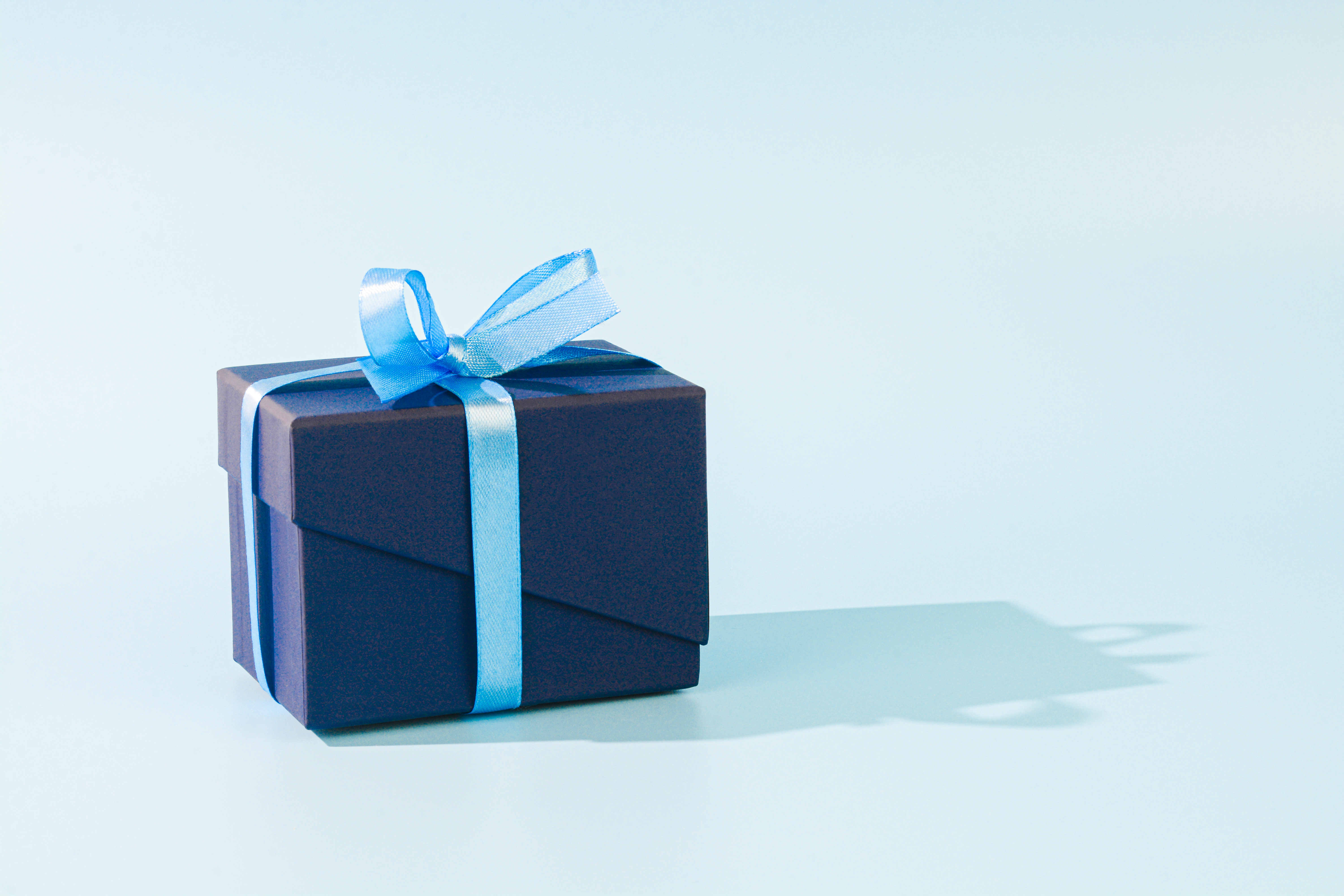 Un regalo envuelto con papel azul oscuro y un lazo azul claro | Foto: Getty Images