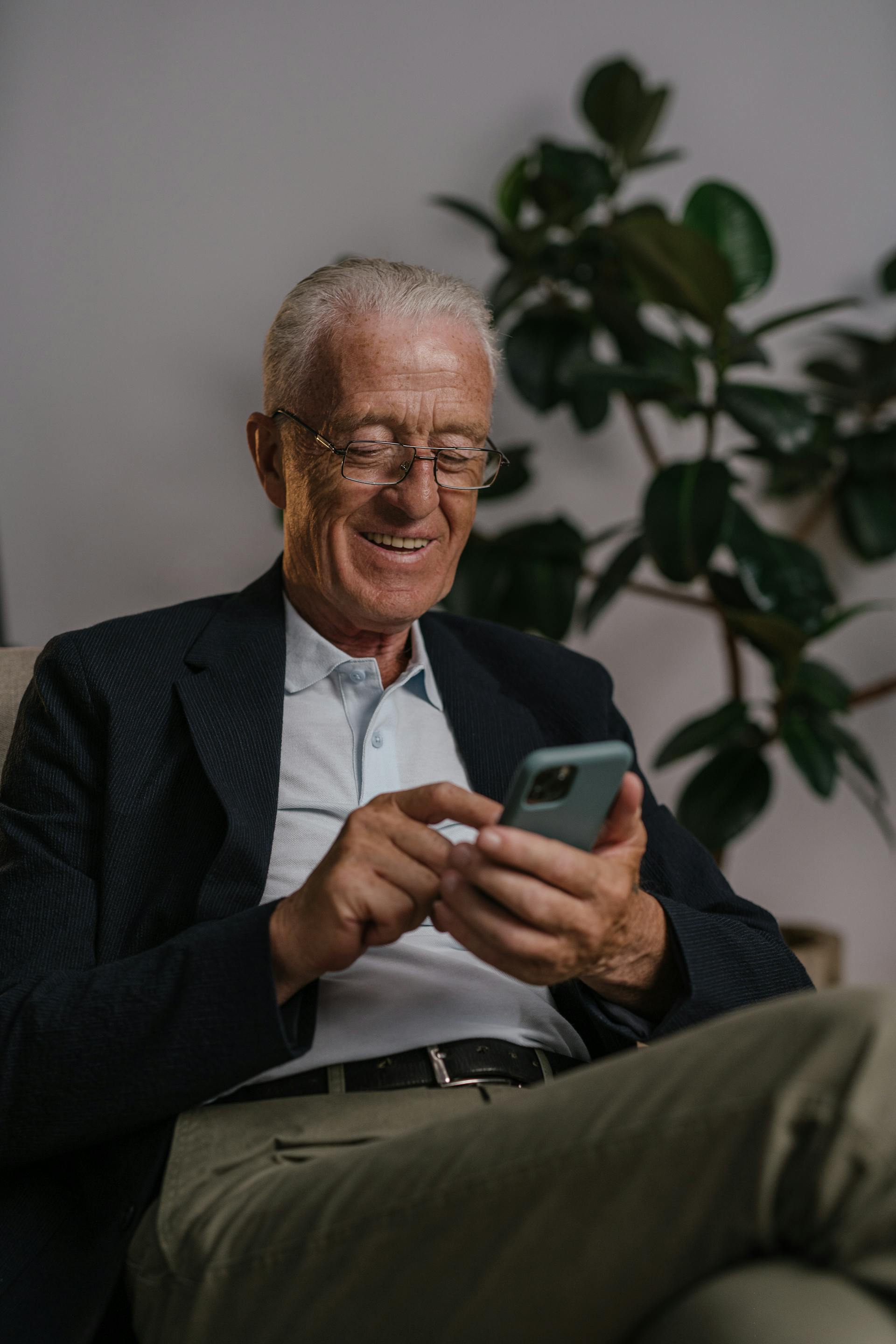 Un hombre feliz con su teléfono | Fuente: Pexels