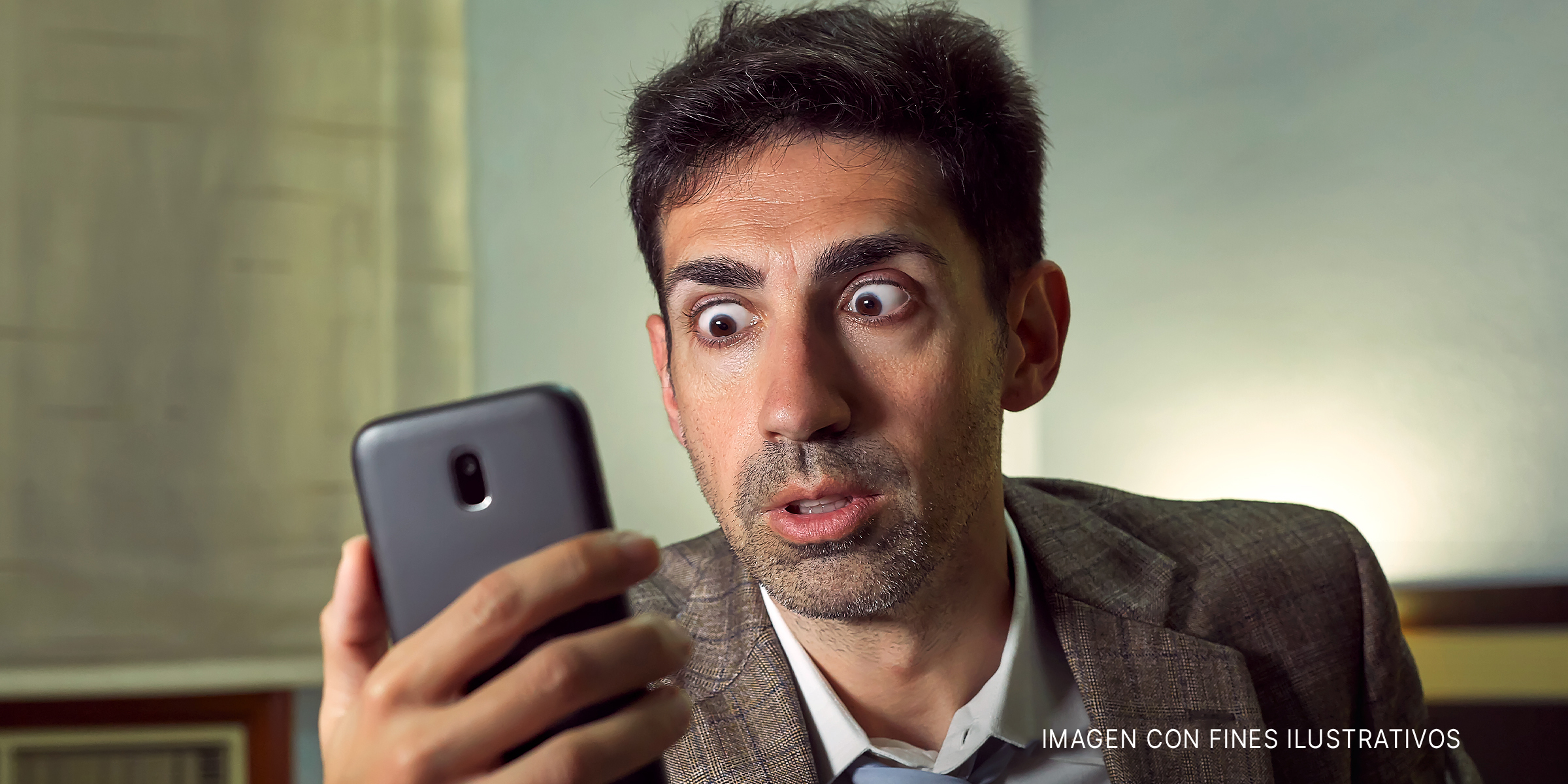 Hombre mirando su teléfono sorprendido | Foto: Shutterstock