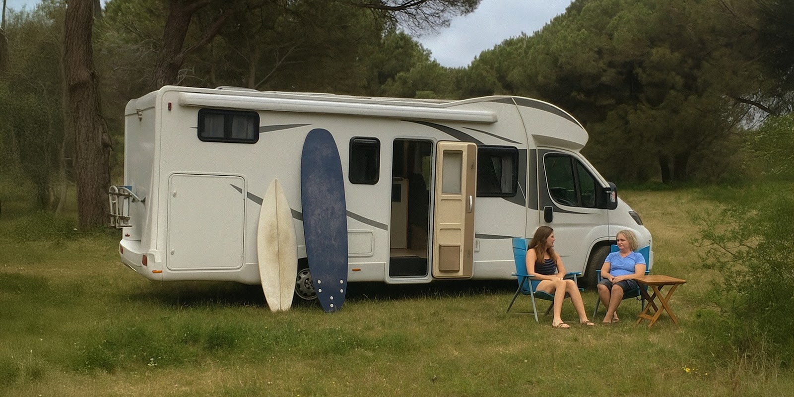 Dos mujeres junto a una furgoneta de camping | Fuente: Sora