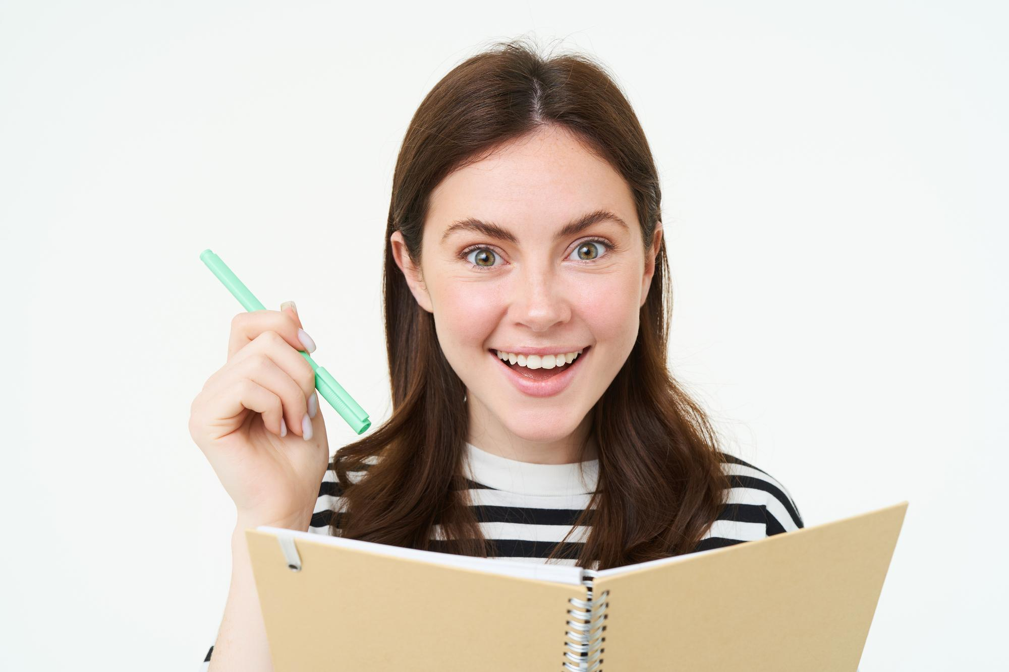 Una mujer con un bolígrafo y un cuaderno en la mano | Fuente: Freepik