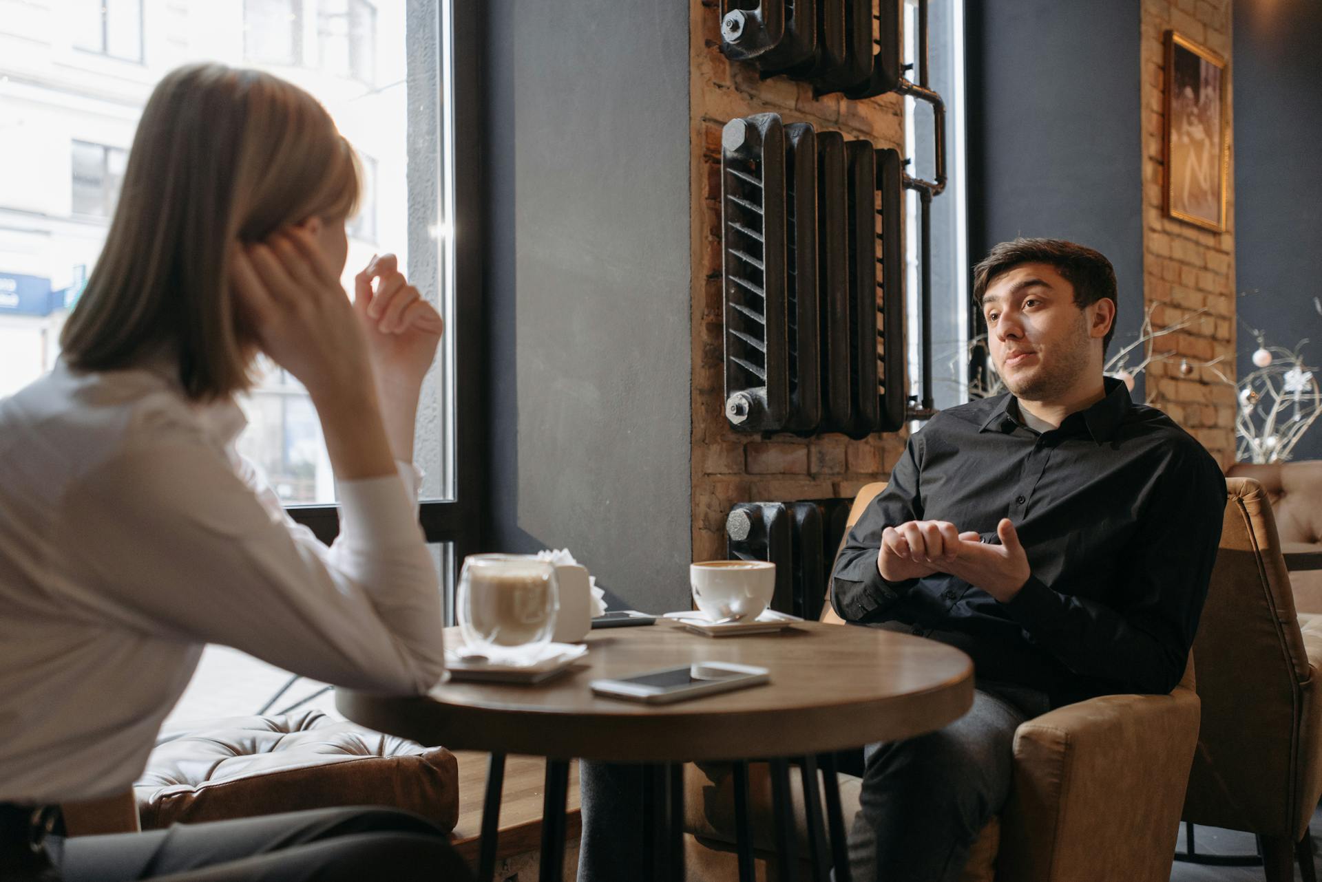 Pareja sentada en una cafetería | Fuente: Pexels