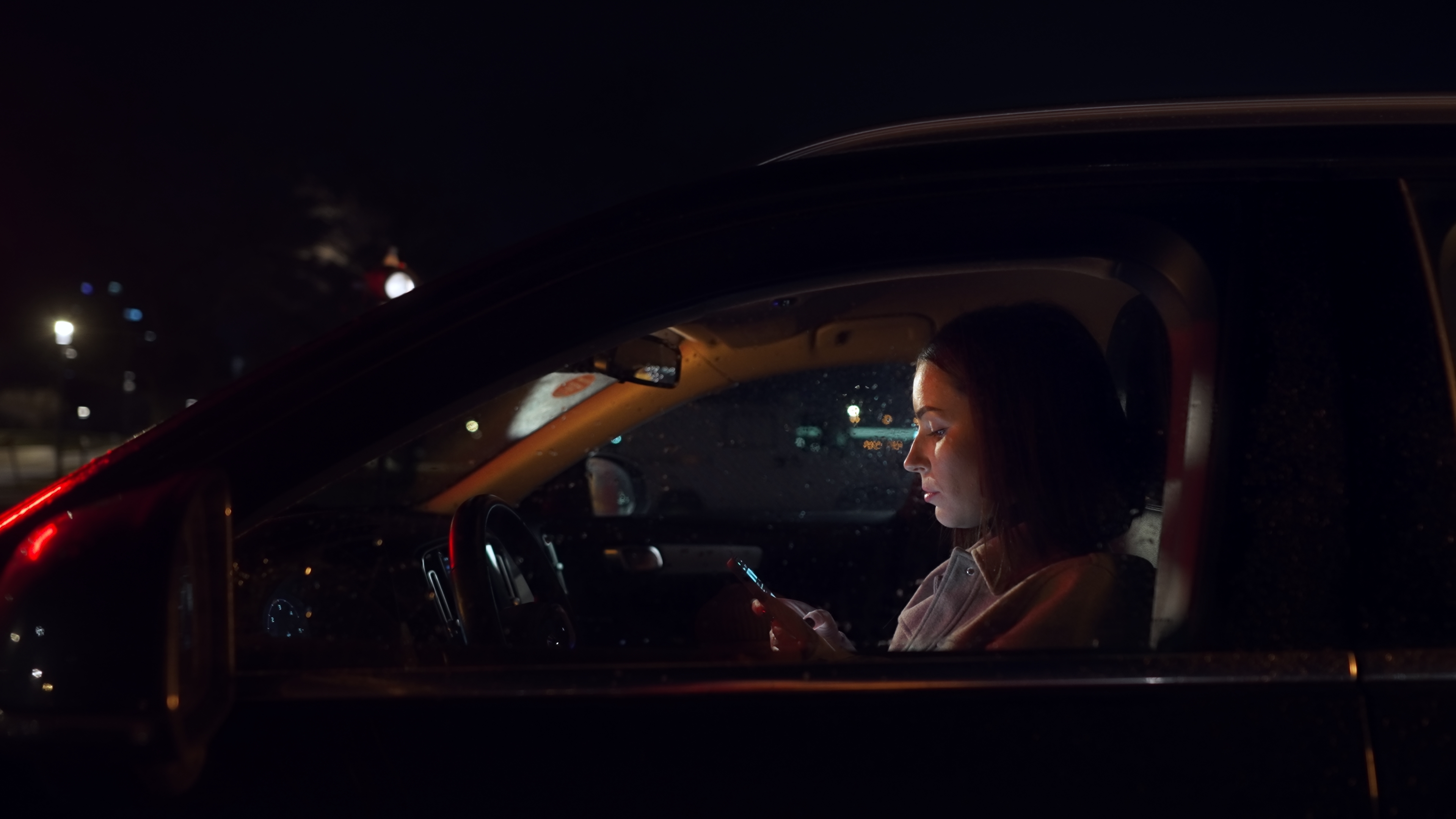 Mujer usando el celular en su vehículo | Foto: Shutterstock