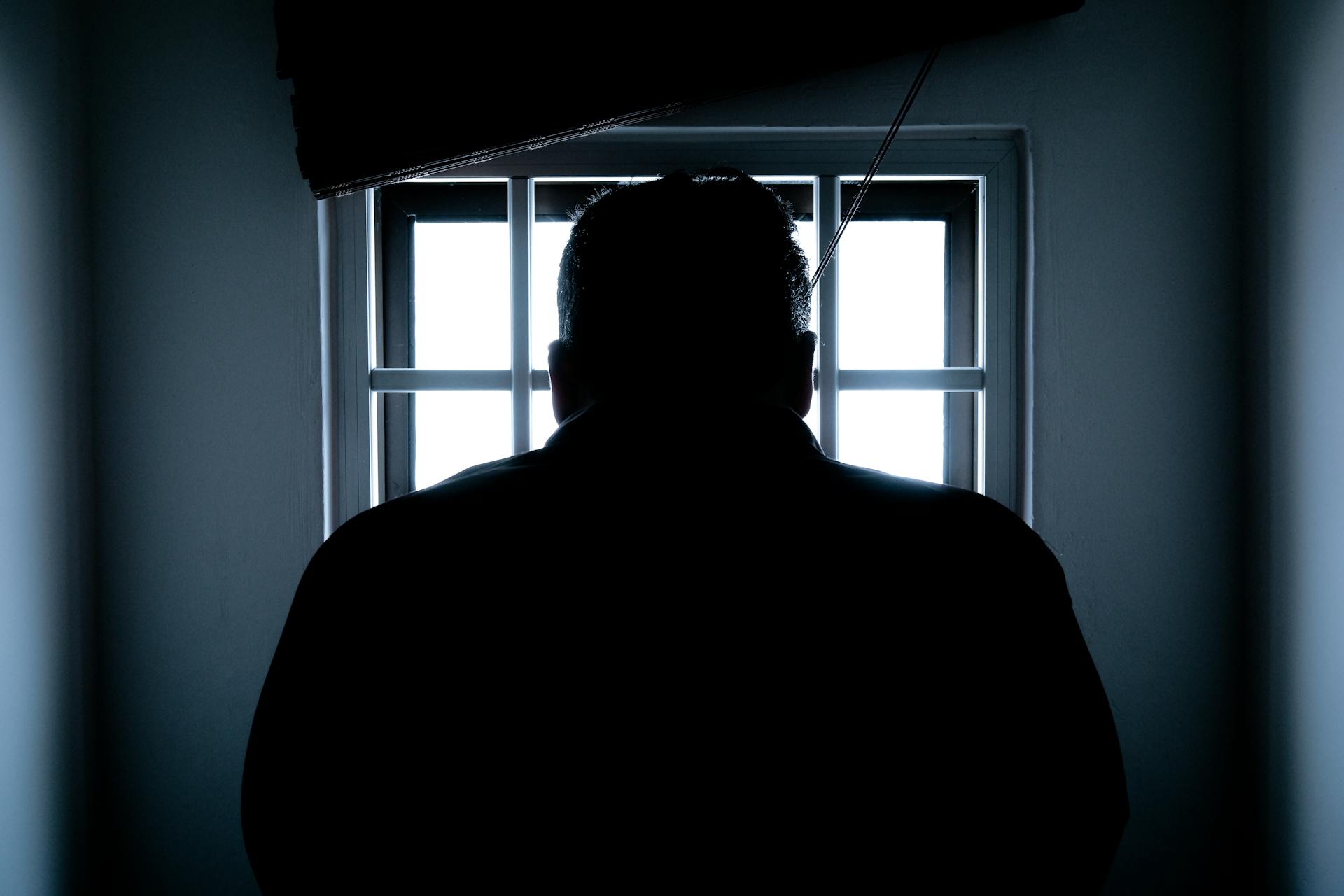 Silueta de un hombre sentado en la cárcel | Fuente: Pexels