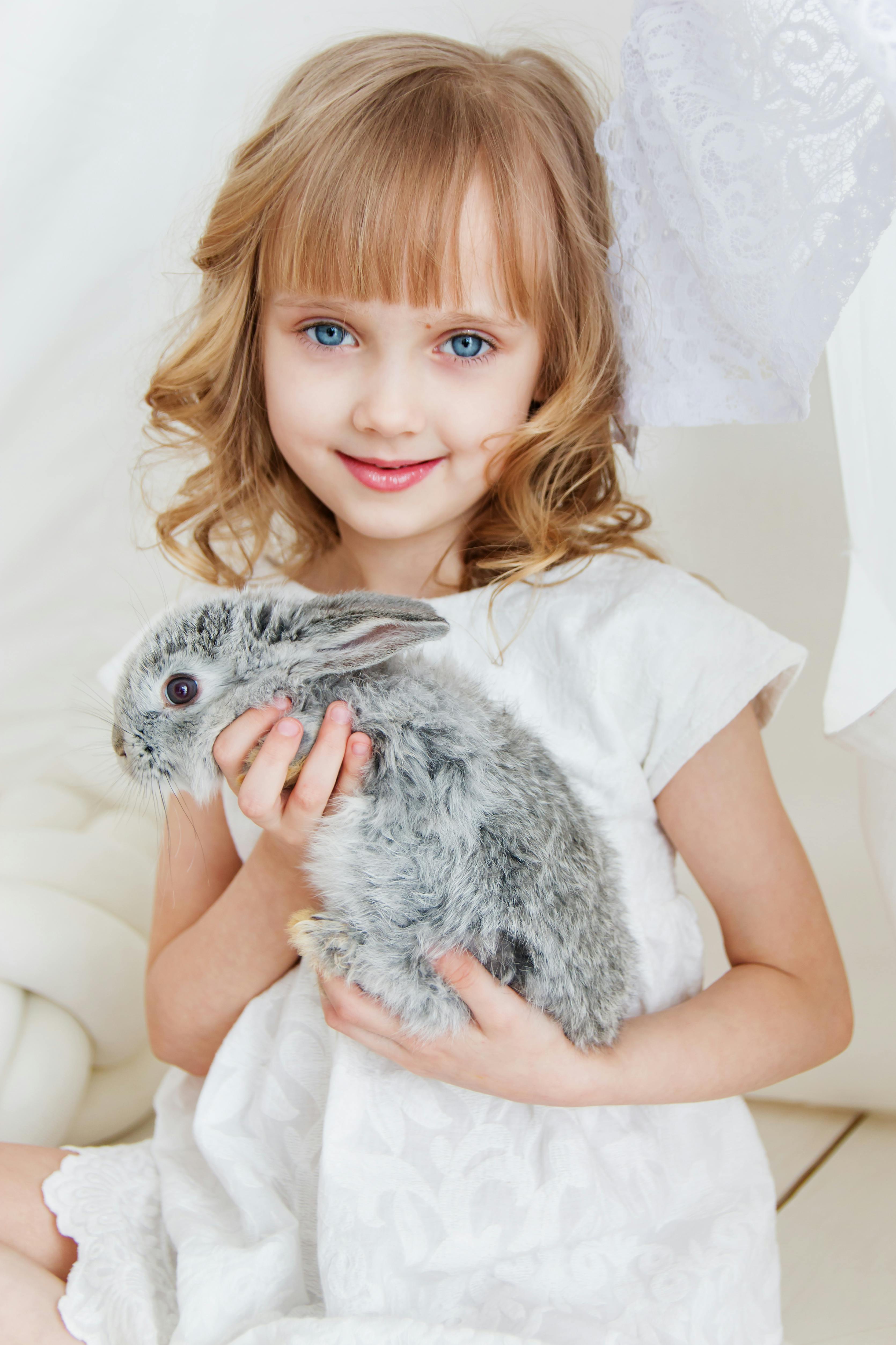 Una niña sonriente con un conejo | Fuente: Pexels