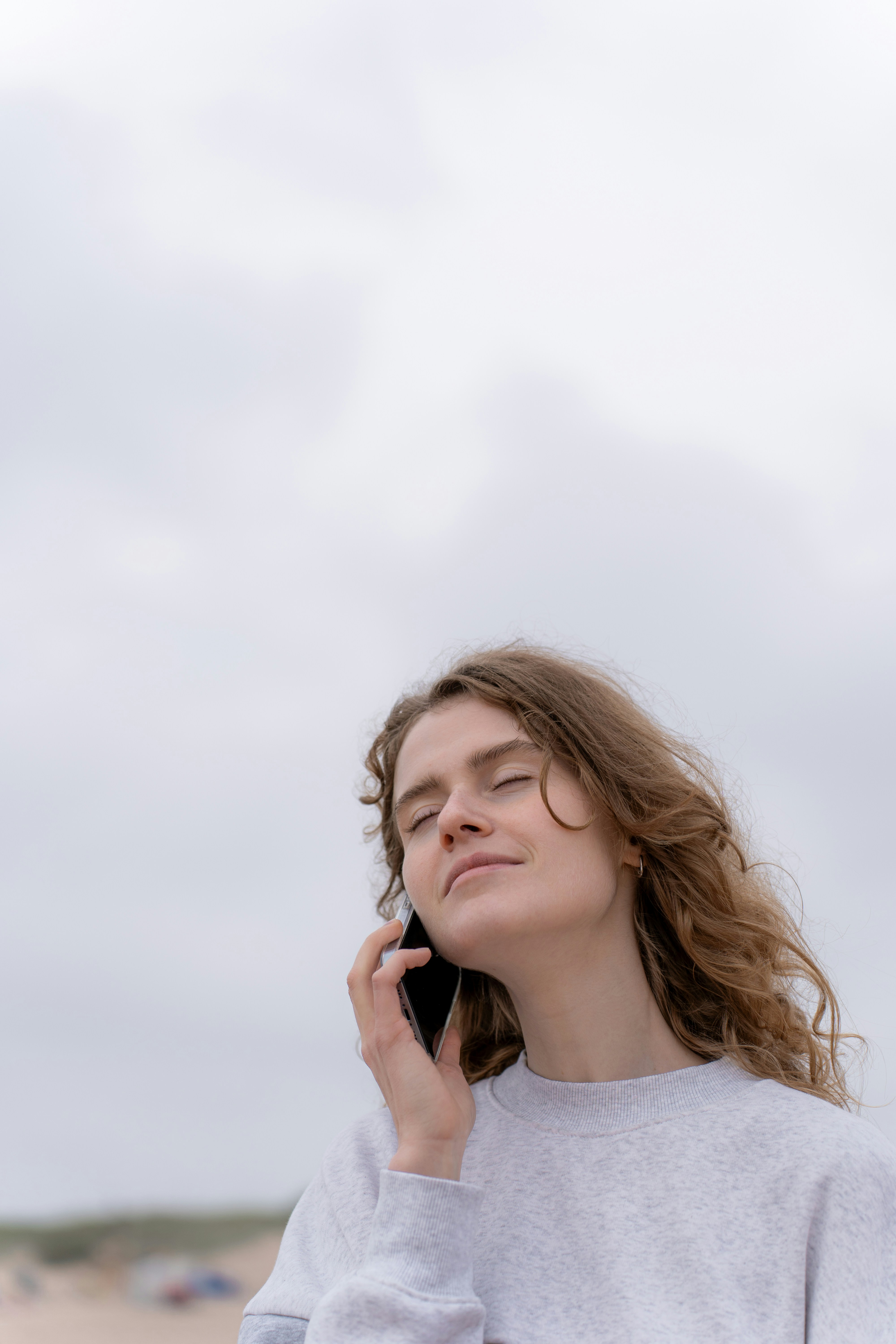 Una mujer con los ojos cerrados hablando por teléfono | Fuente: Unsplash