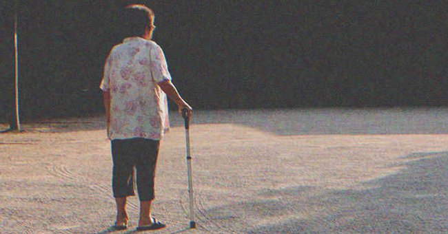 Una anciana con un baston mira a lo lejos en una calle. | Foto: Shutterstock