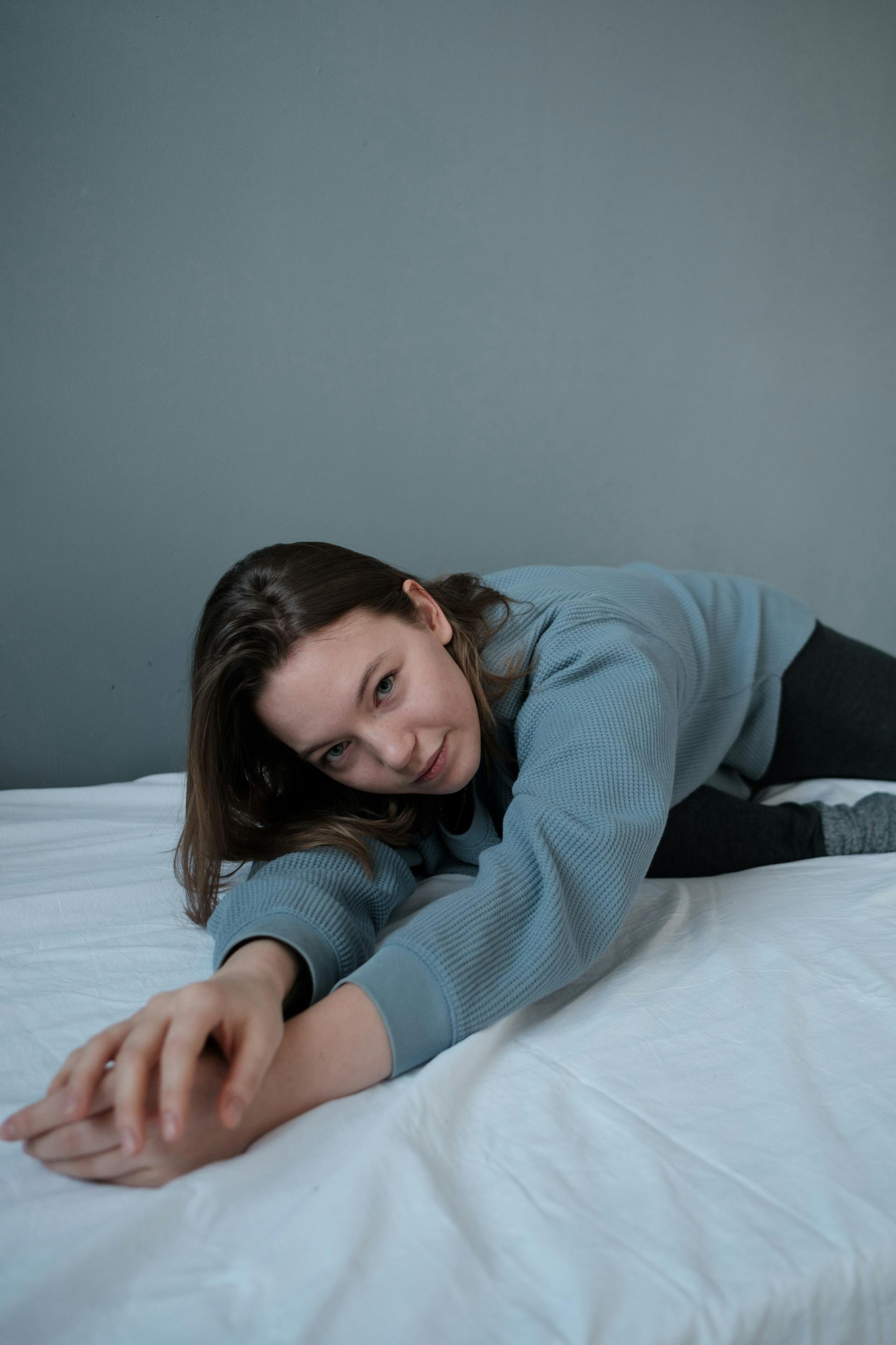 Una adolescente tumbada en una cama deshecha | Fuente: Pexels