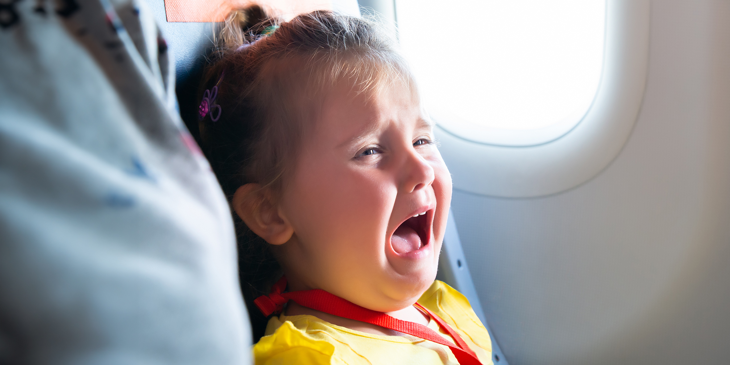 Una niña llorando en un avión | Fuente: Shutterstock