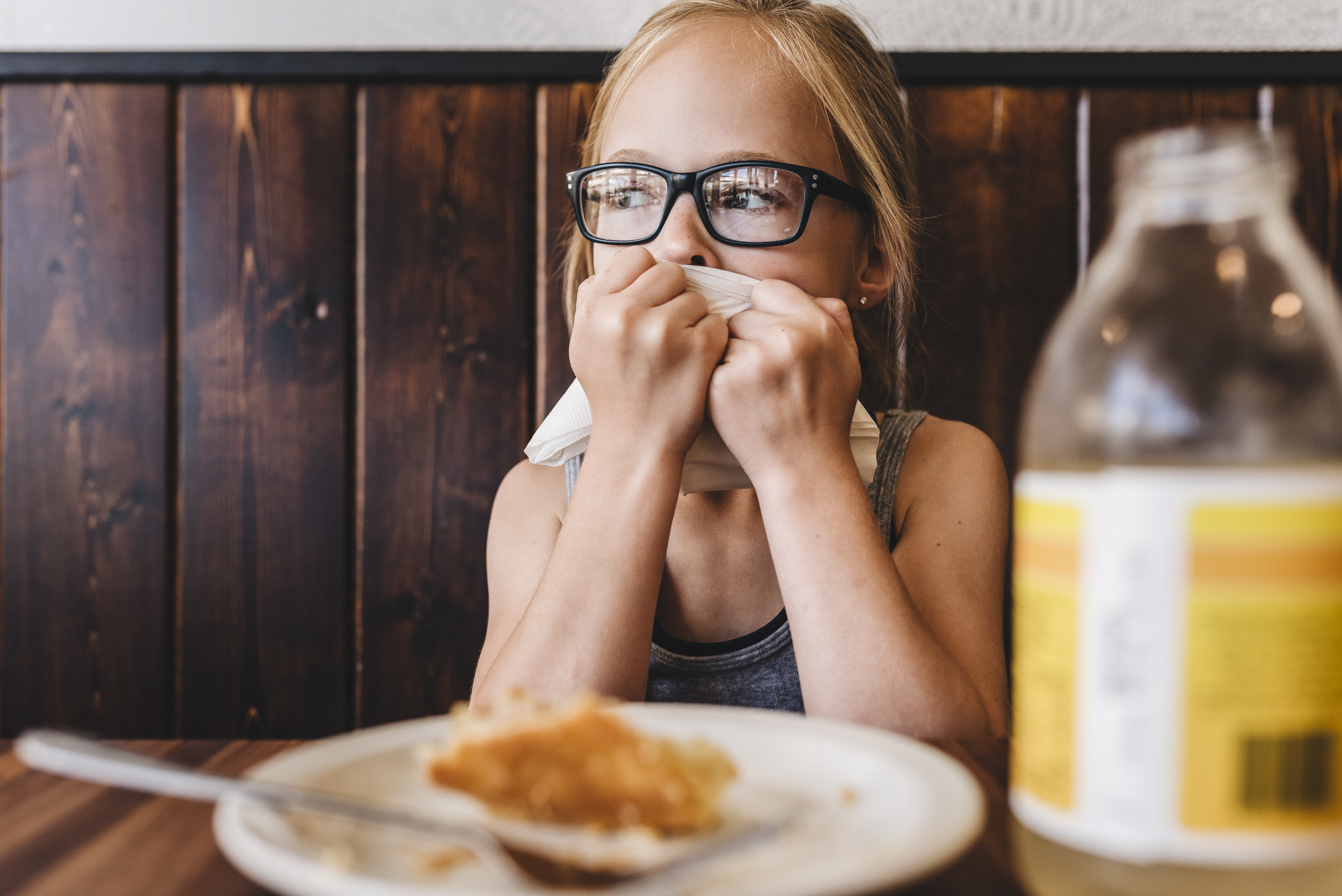 Niña come y bebe en la mesa de un café restaurante | Foto: Getty Images