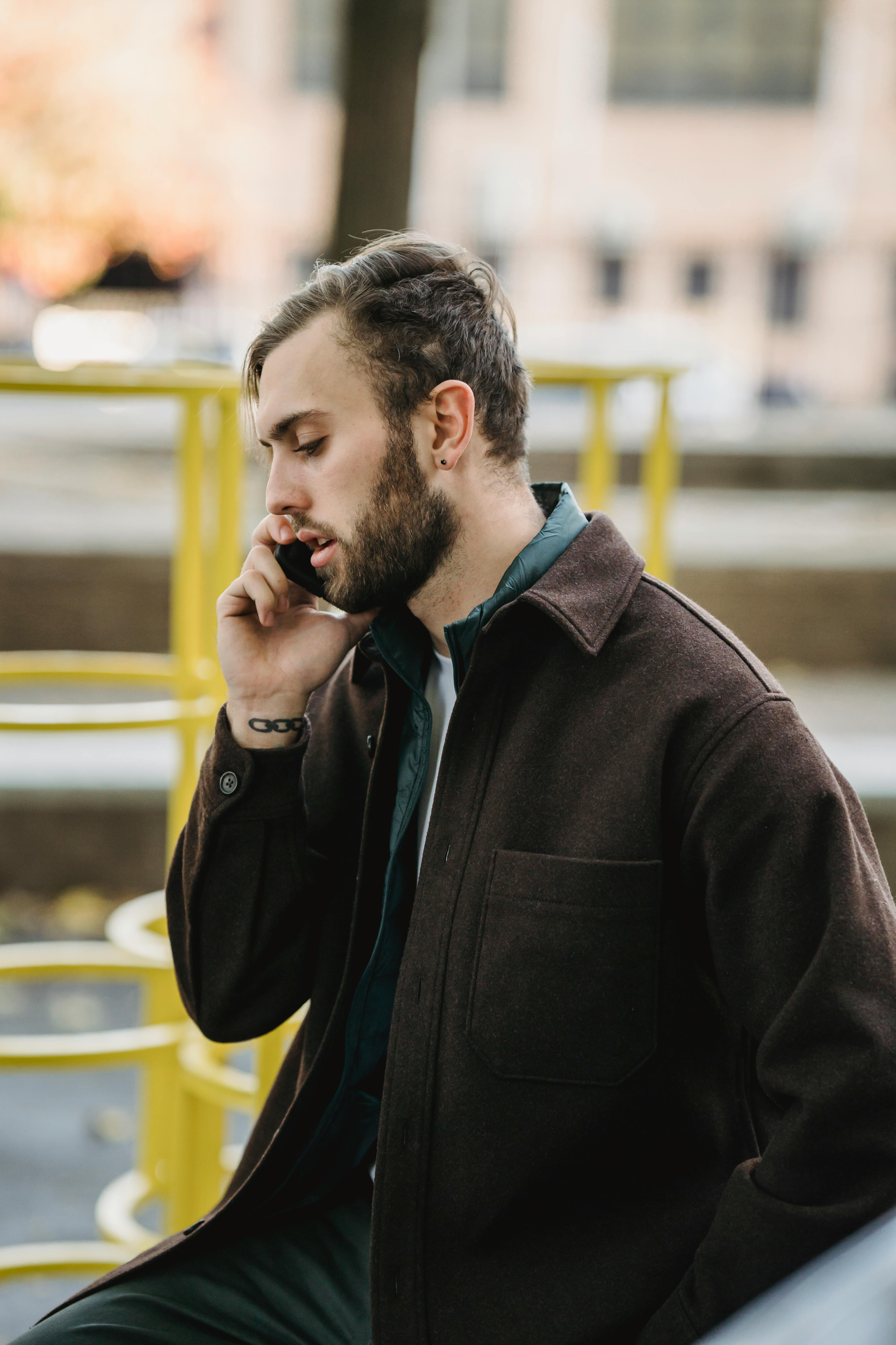 Un hombre pensativo hablando por teléfono en la calle | Fuente: Pexels