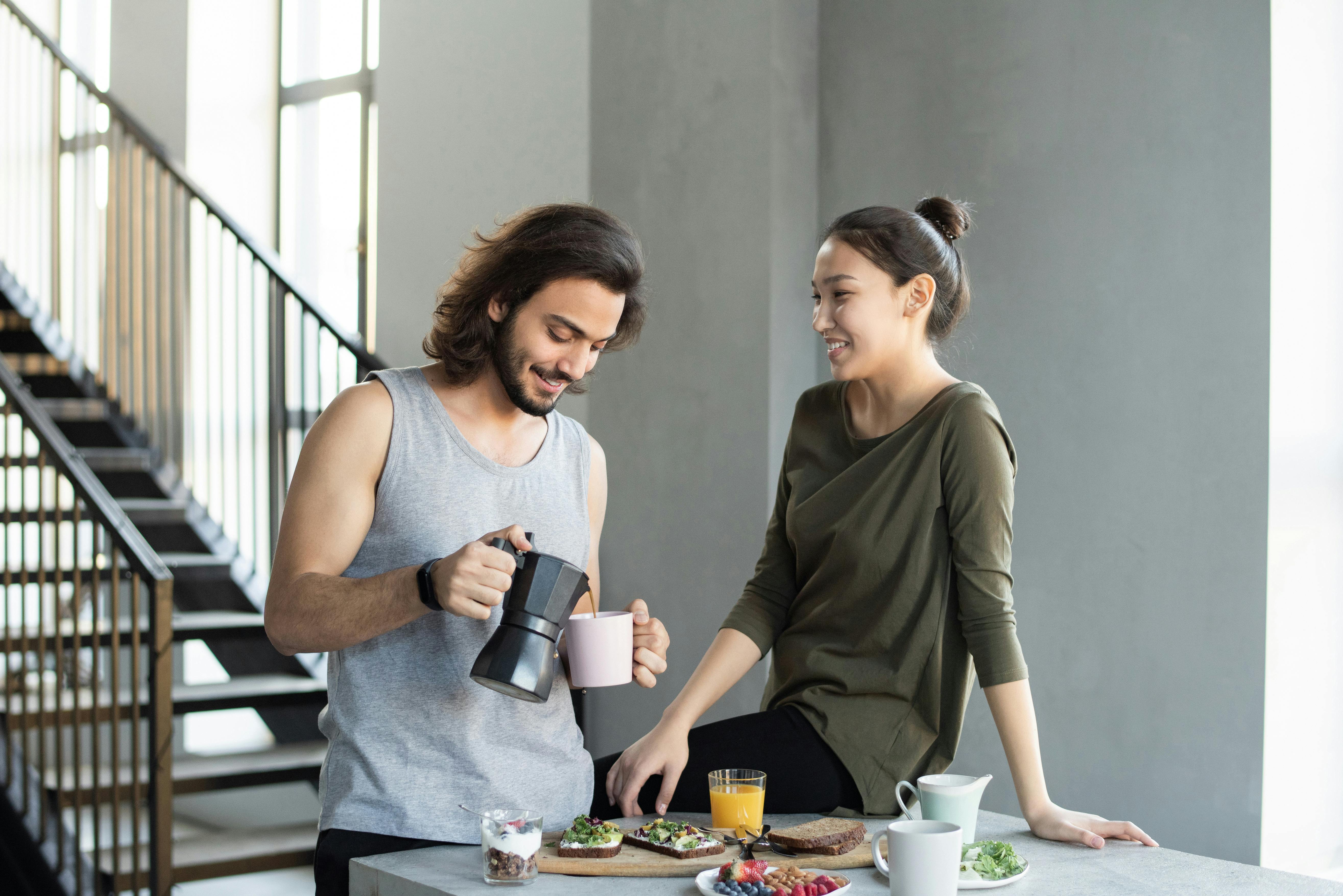 Una pareja feliz desayunando | Fuente: Pexels