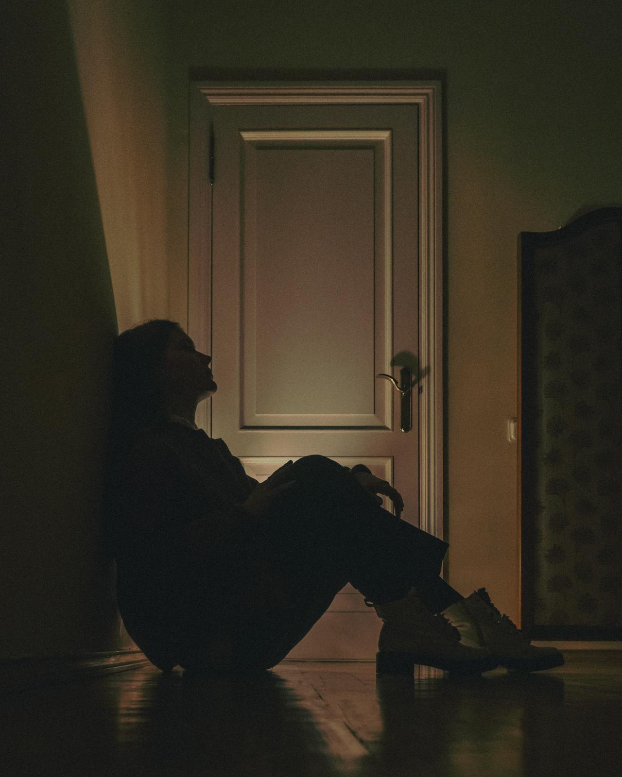 Una joven derrotada sentada en el suelo | Fuente: Pexels