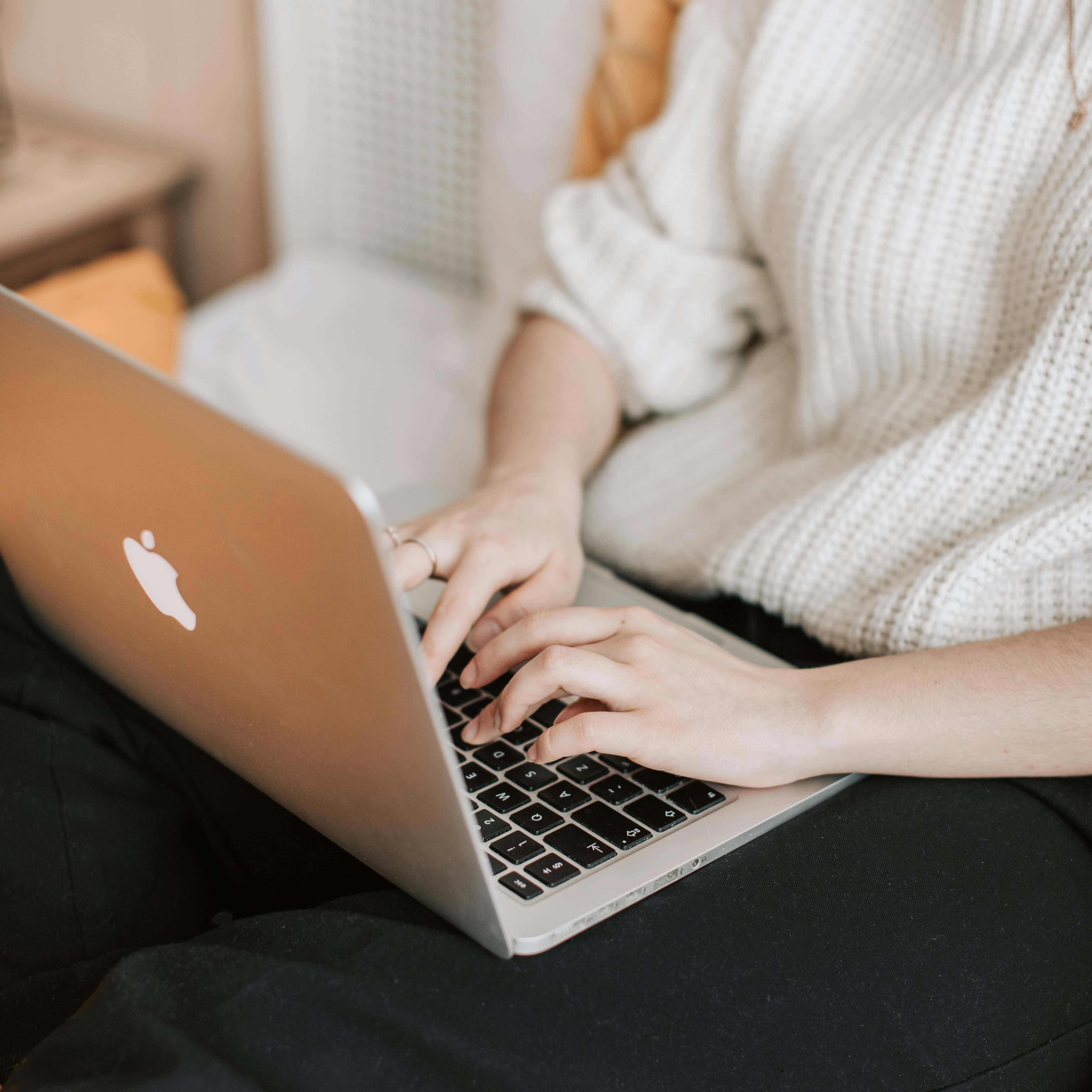 Una mujer sentada en la cama, trabajando en un portátil | Fuente: Pexels