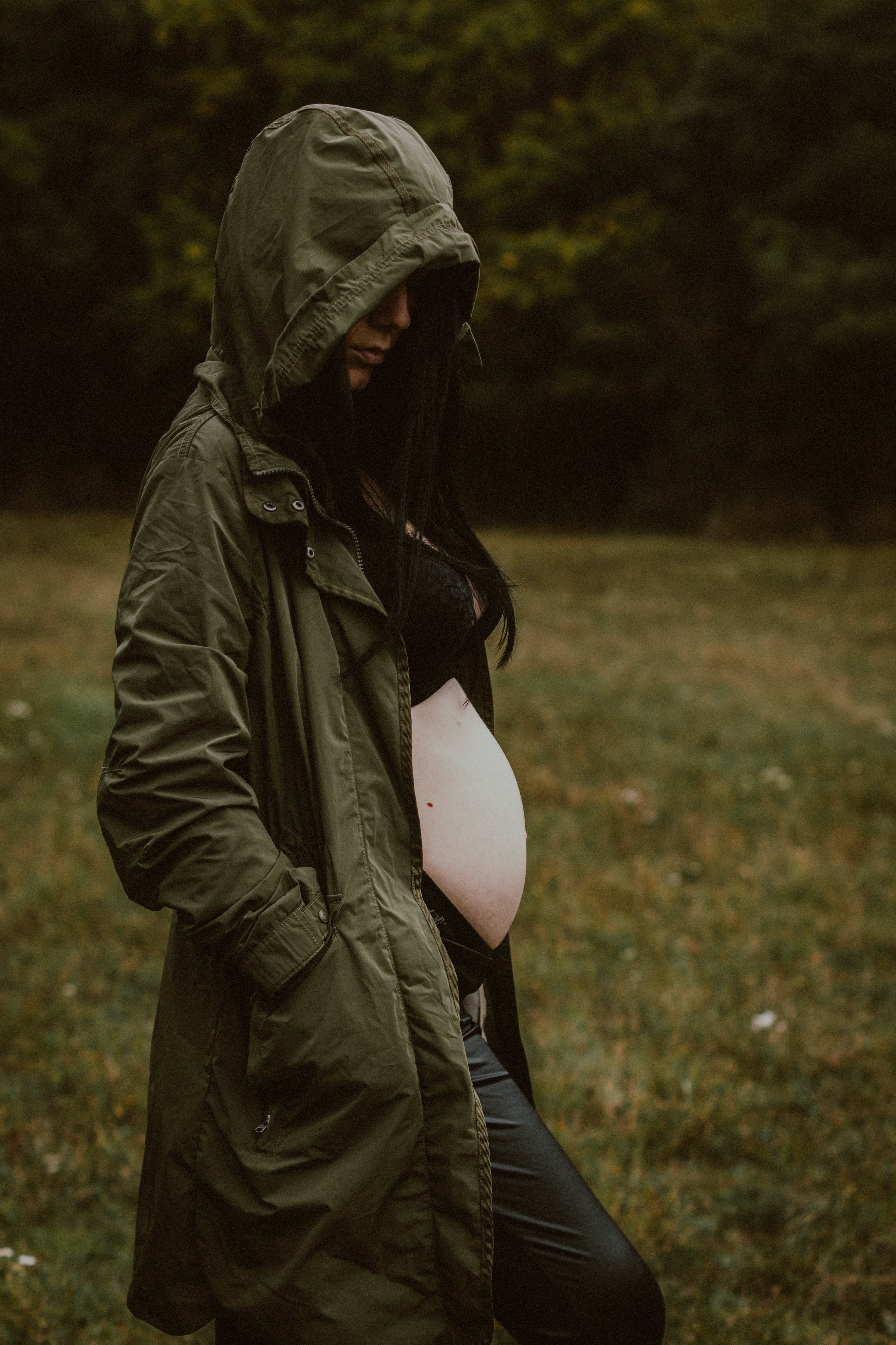 Una mujer embarazada con un abrigo verde con capucha. | Fuente: Pexels