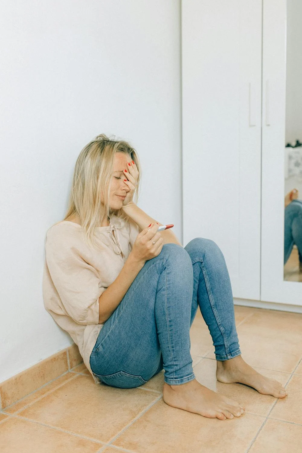 Una mujer feliz y nerviosa mirando su test de embarazo | Fuente: Pexels