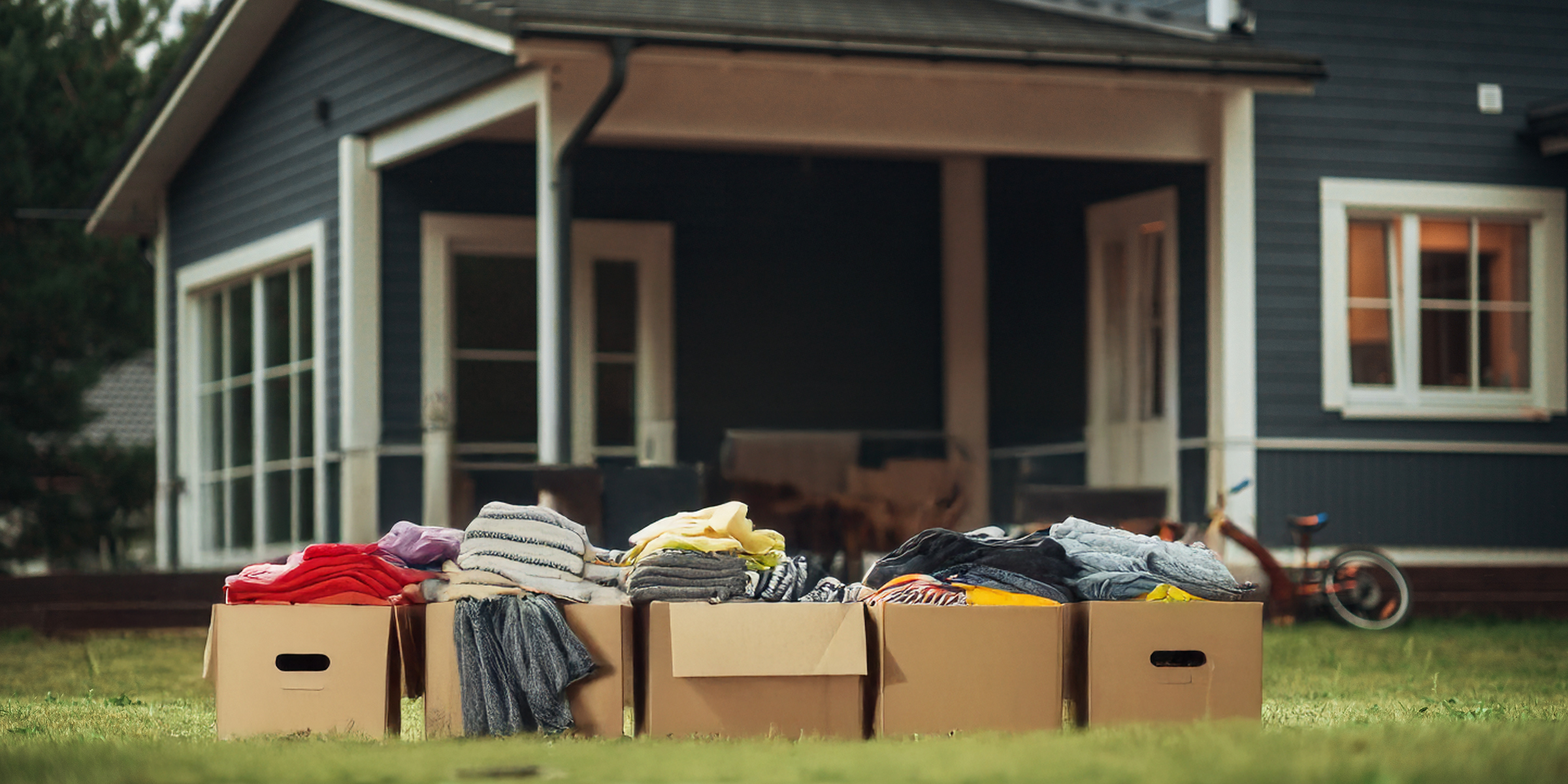 Un montón de ropa en cajas apiladas fuera de una casa | Fuente: Shutterstock