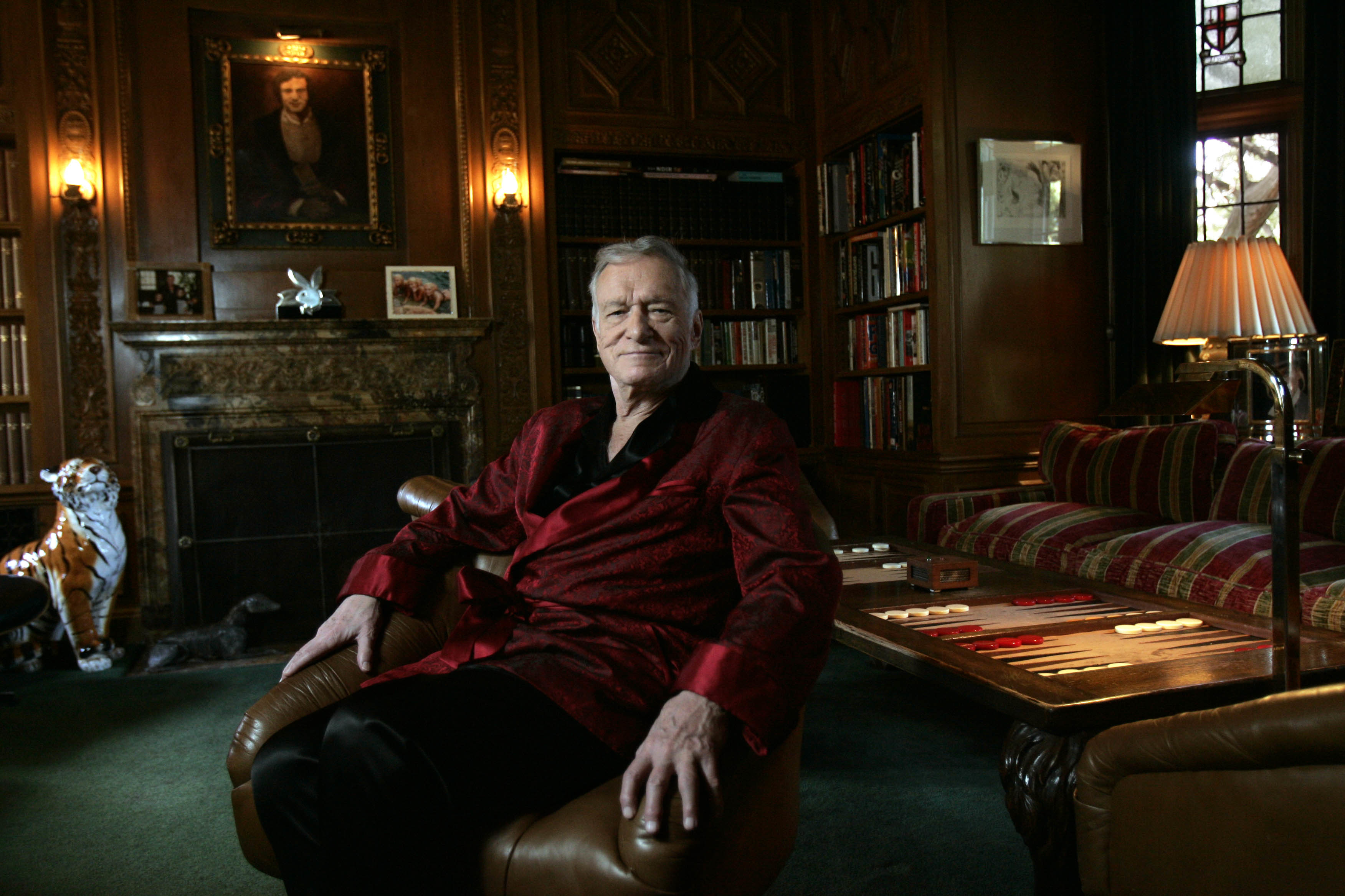 El fundador de Playboy, Hugh Hefner, aparece sentado en su mansión de Los Ángeles el 26 de febrero de 2009. El actor Bill Pullman interpreta al fallecido editor en "Playmates", que sigue a una aspirante a Playmate y una adolescente que entablan una amistad inesperada. | Fuente: Getty Images