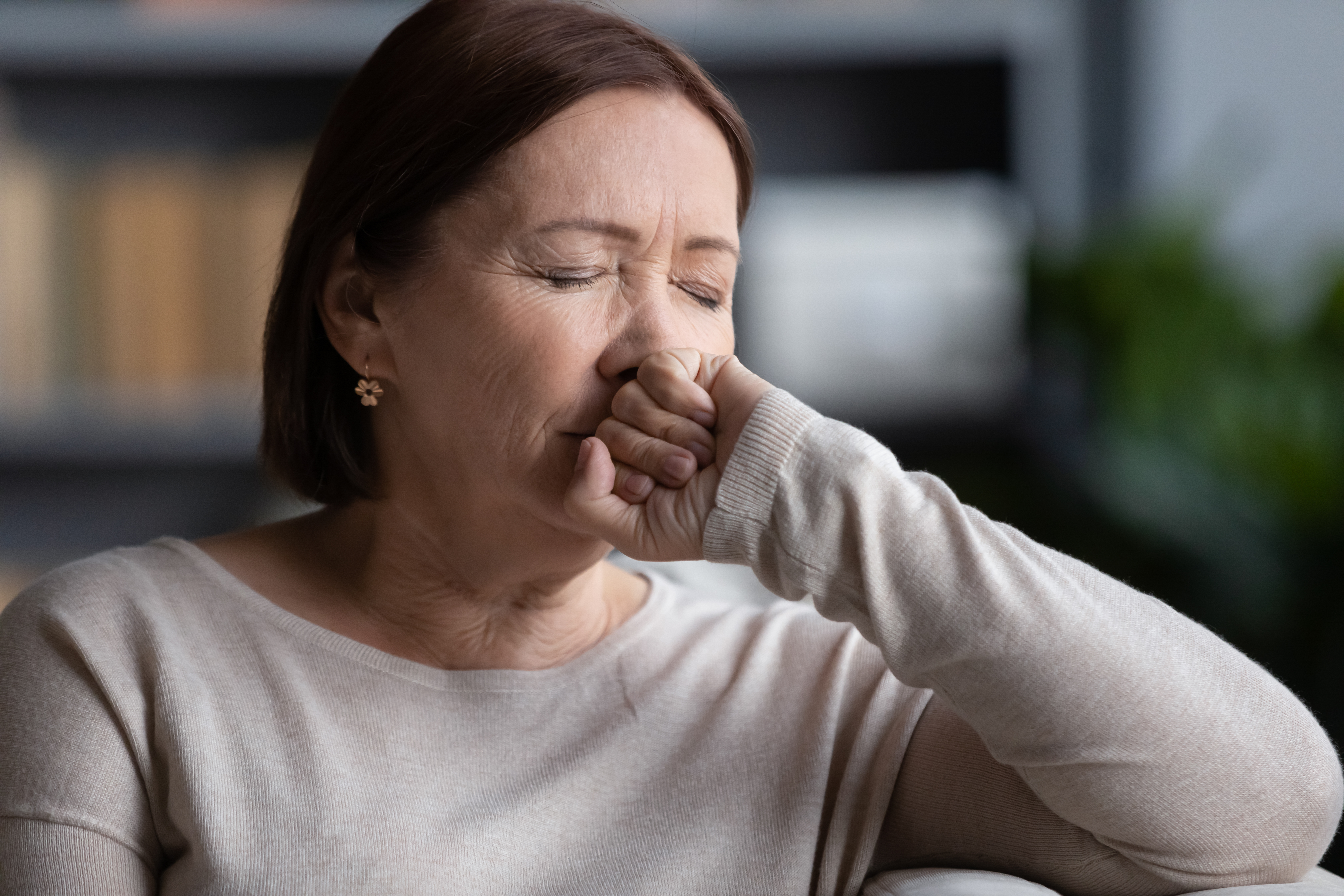 Una mujer estresada sentada con los ojos cerrados | Fuente: Shutterstock
