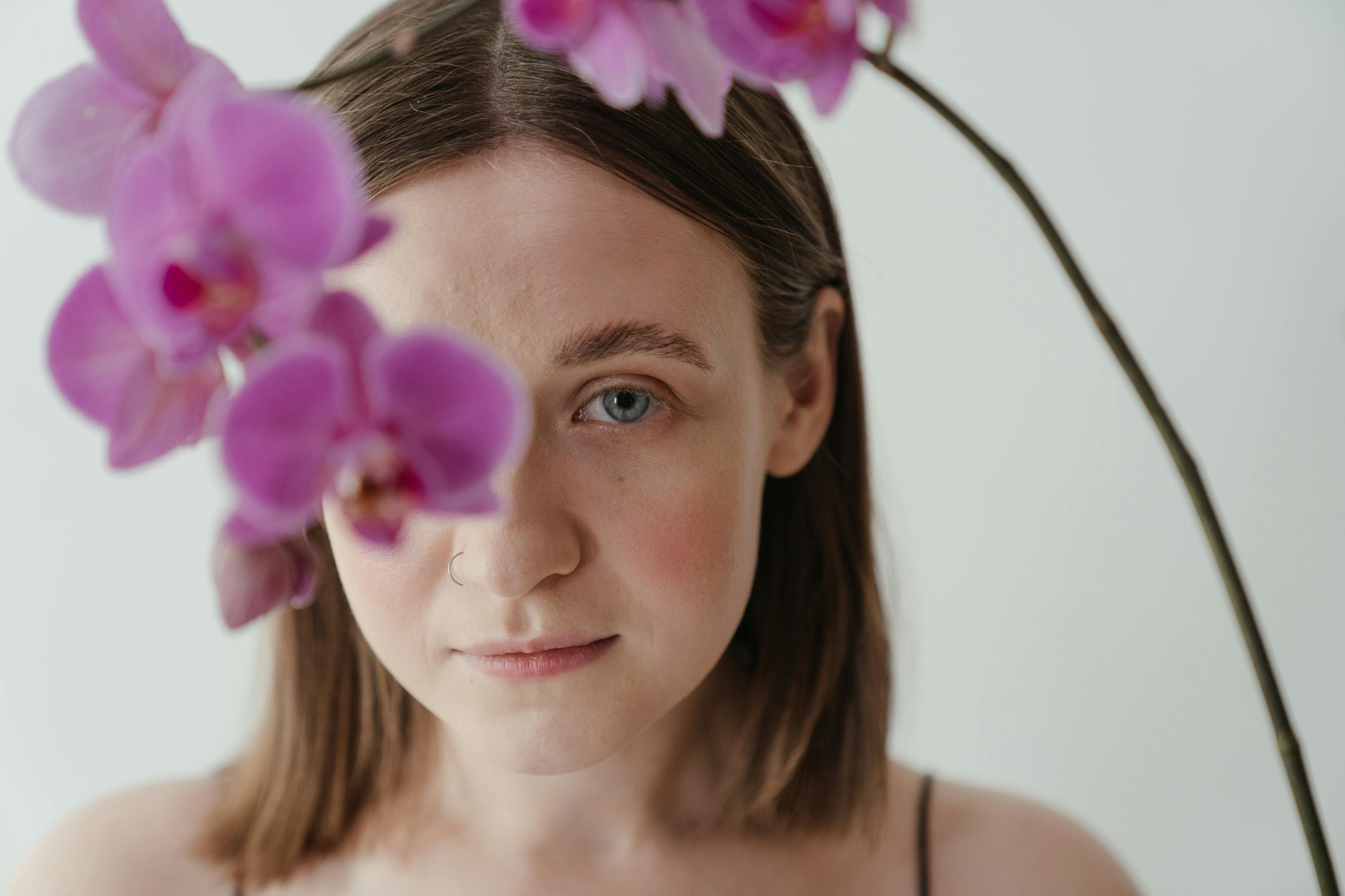 Una mujer posando con flores moradas | Fuente: Pexels