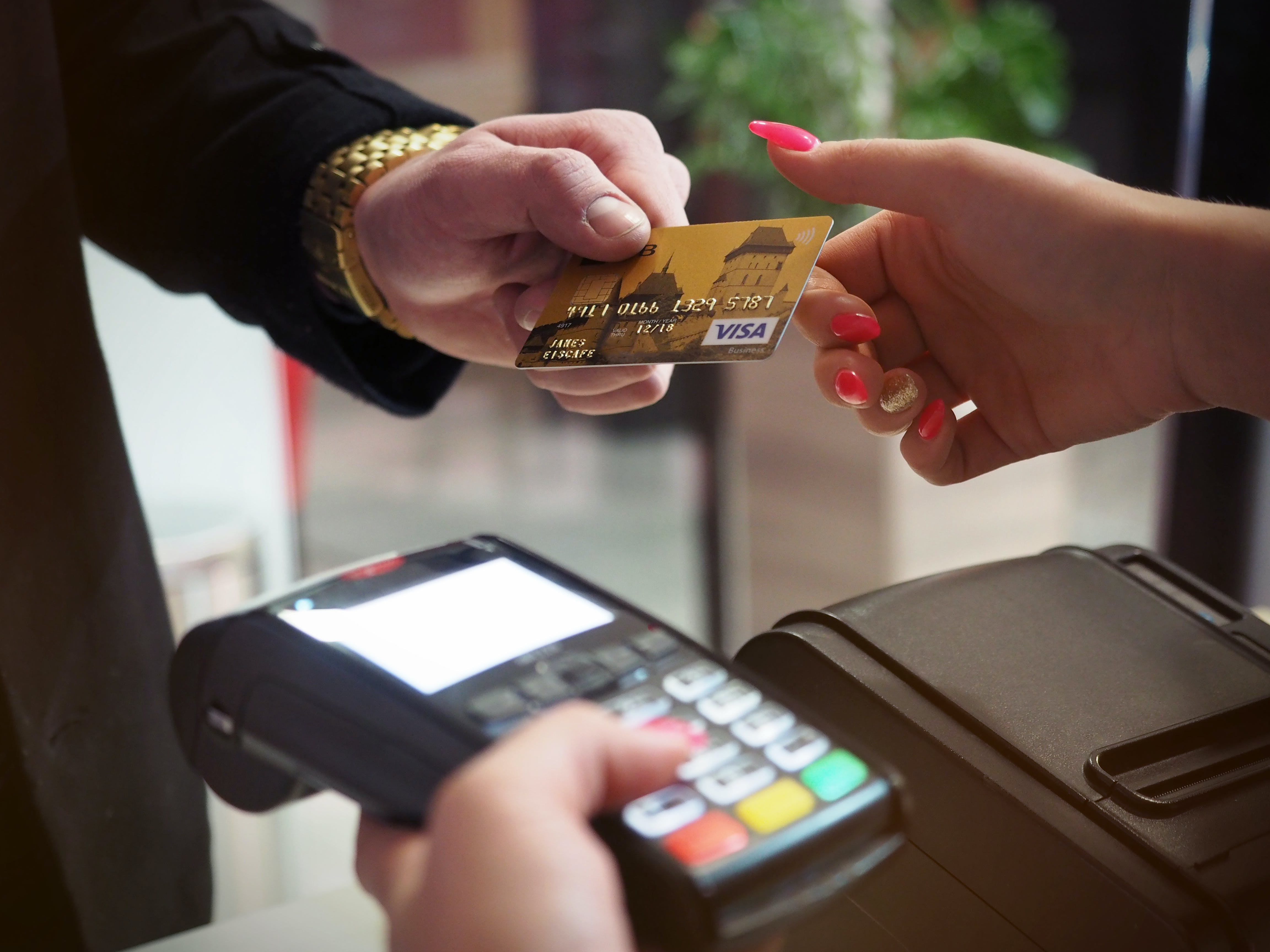 Una persona que paga servicios utilizando una tarjeta de cajero automático. | Fuente: Pexels