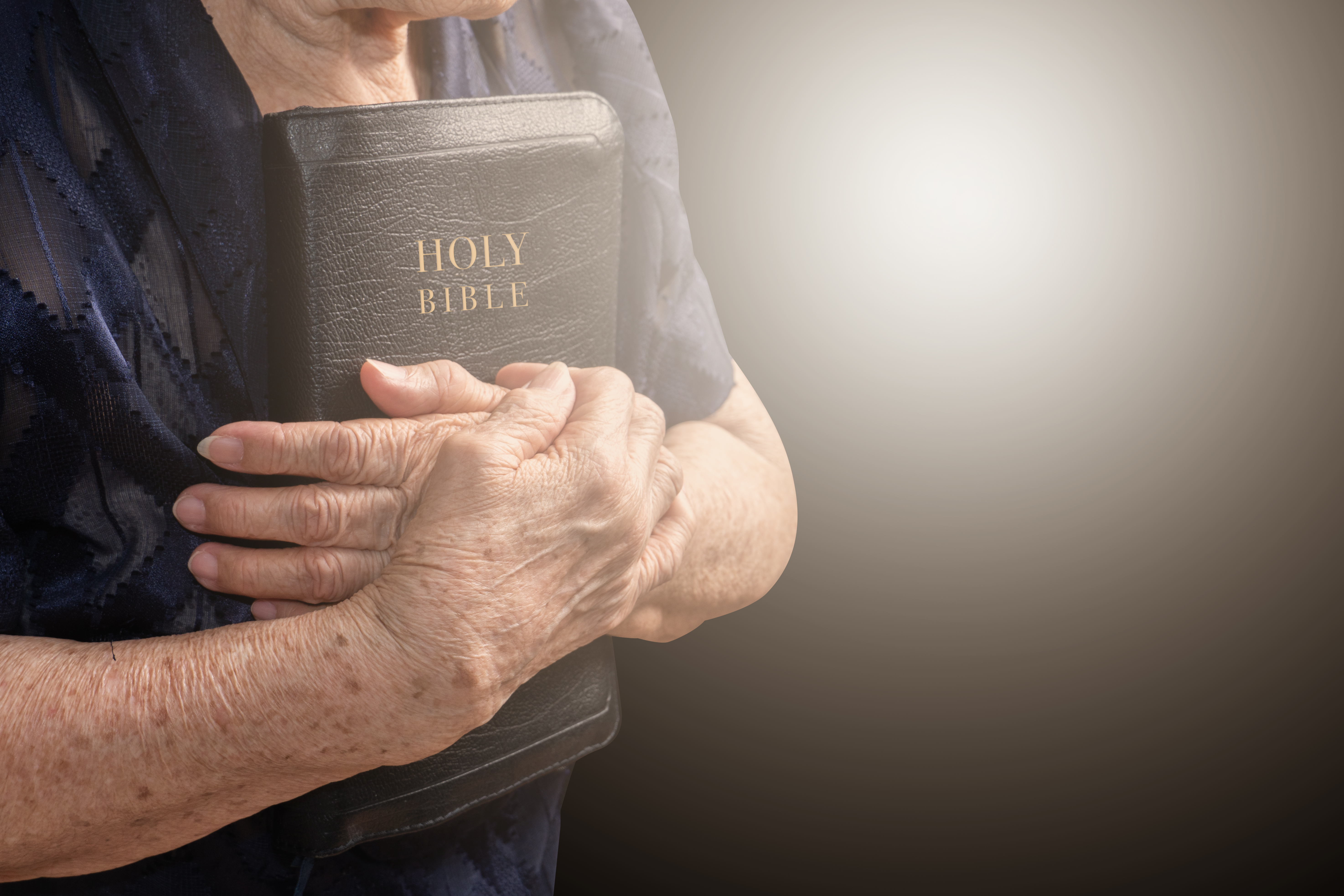 Mujer mayor sosteniendo una biblia | Fuente: Shutterstock