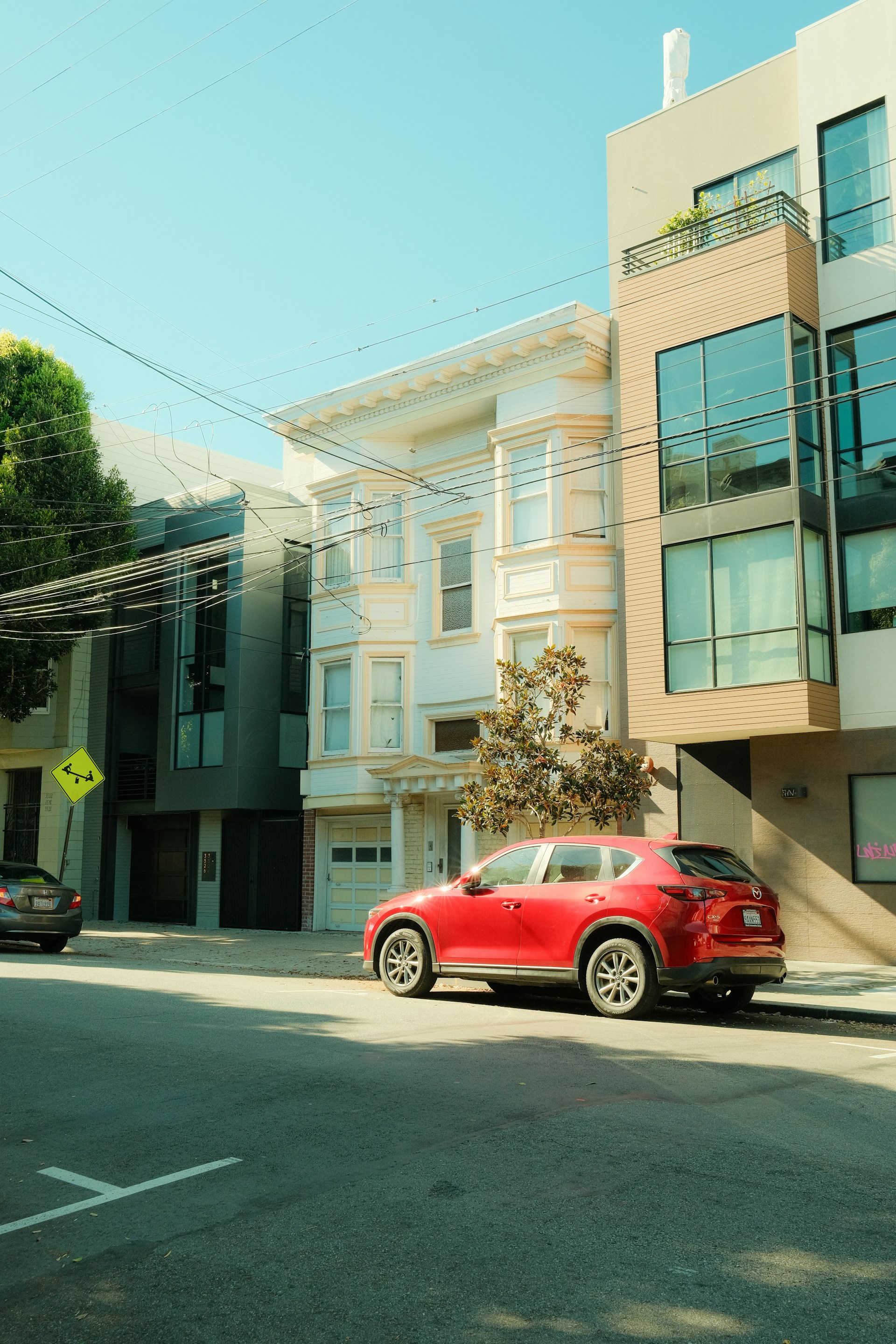 Un'auto rossa in un quartiere | Fonte: Unsplash