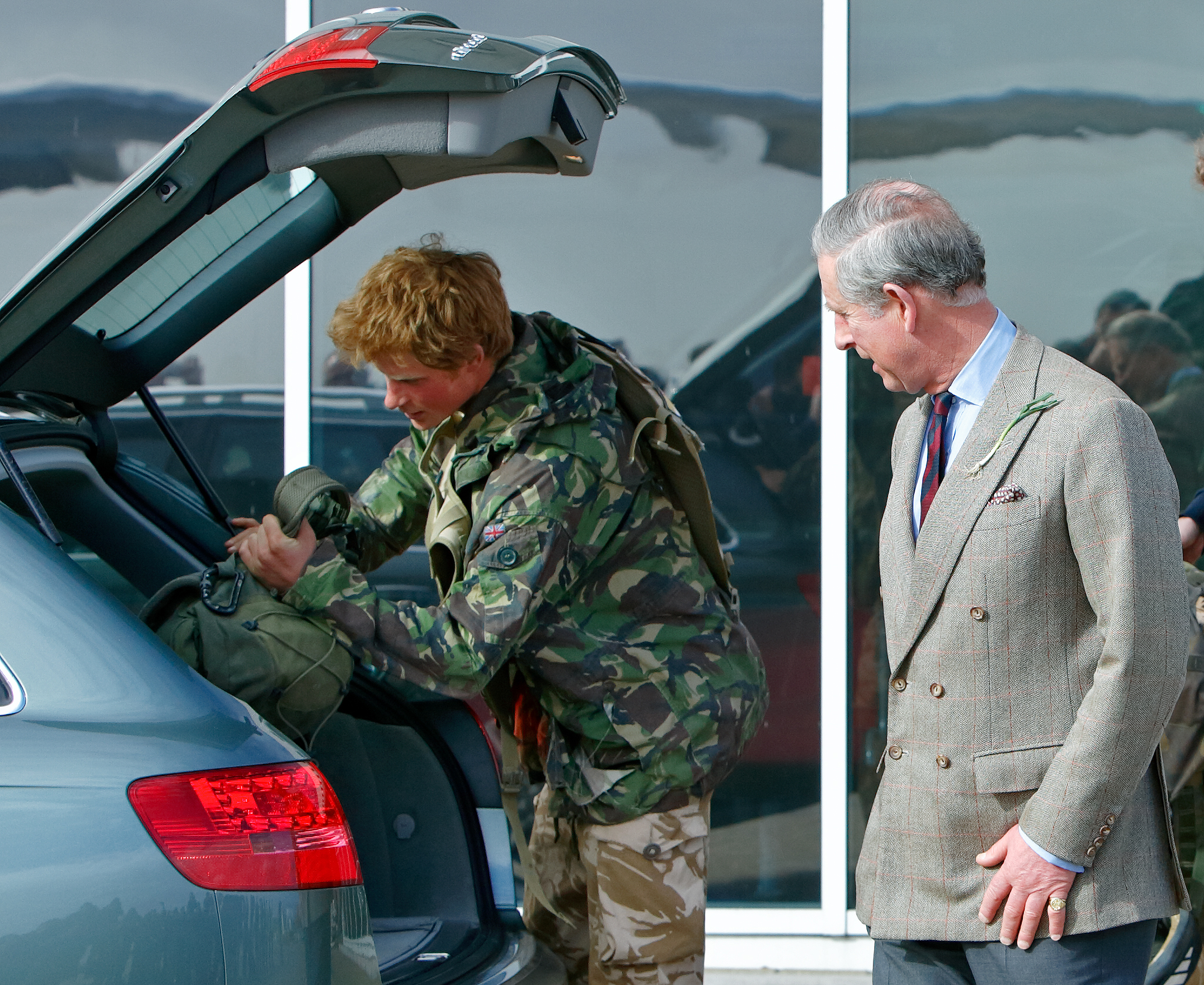 El príncipe Harry carga las bolsas de su equipo en compañía de su padre, el príncipe Charles, el 1 de marzo de 2008 en Brize Norton, Inglaterra | Fuente: Getty Images