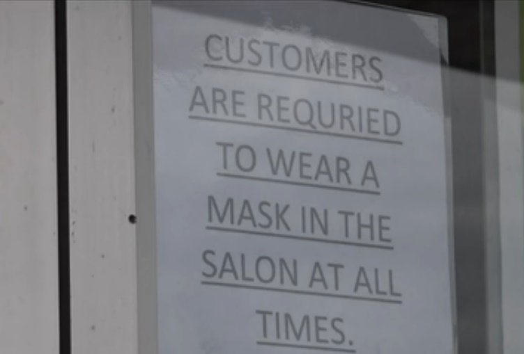 Letrero en el que se exige a los clientes de la peluquería usar mascarillas en el local todo el tiempo. | Foto: YouTube/11Alive
