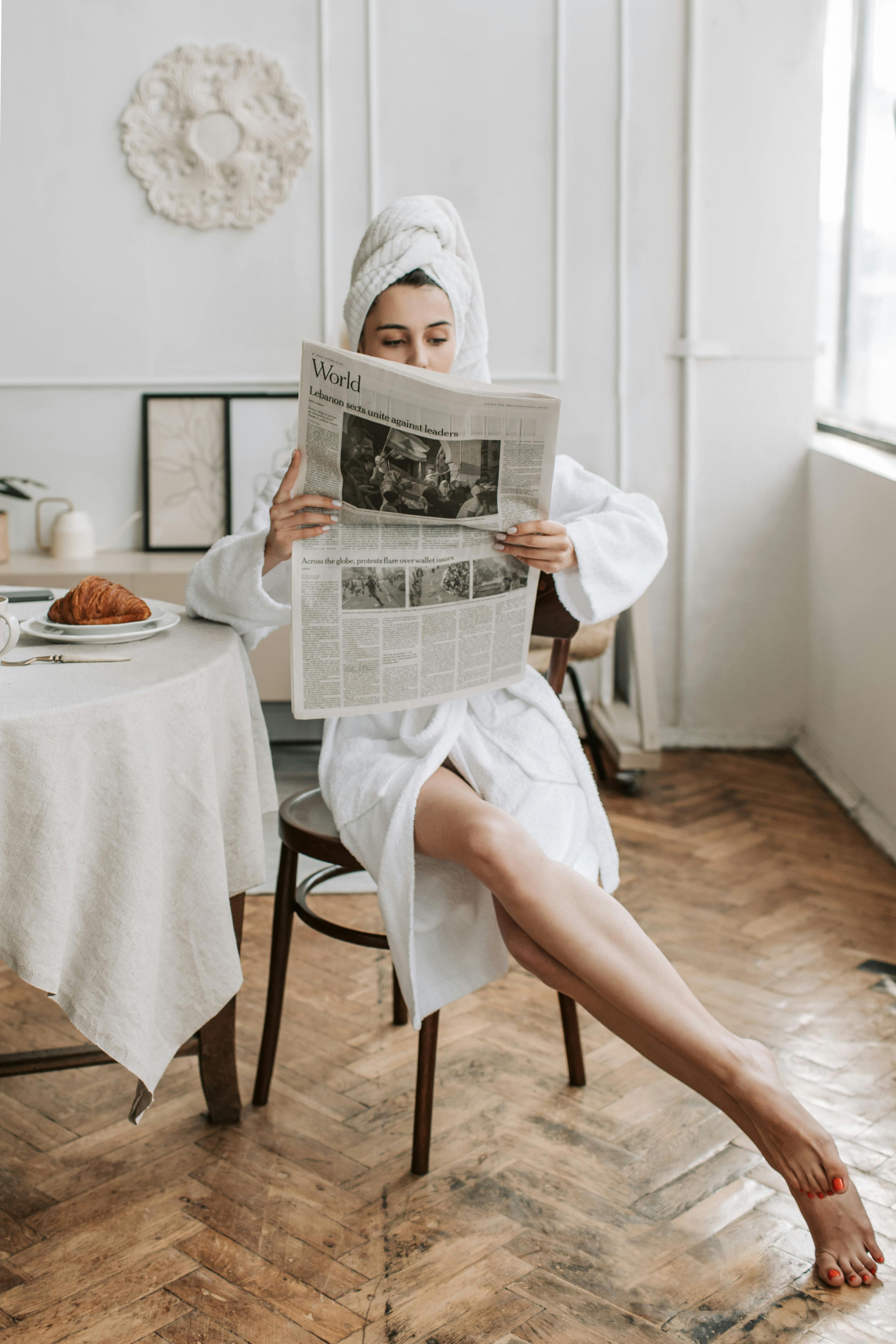 Una mujer leyendo el periódico después de ducharse | Fuente: Pexels