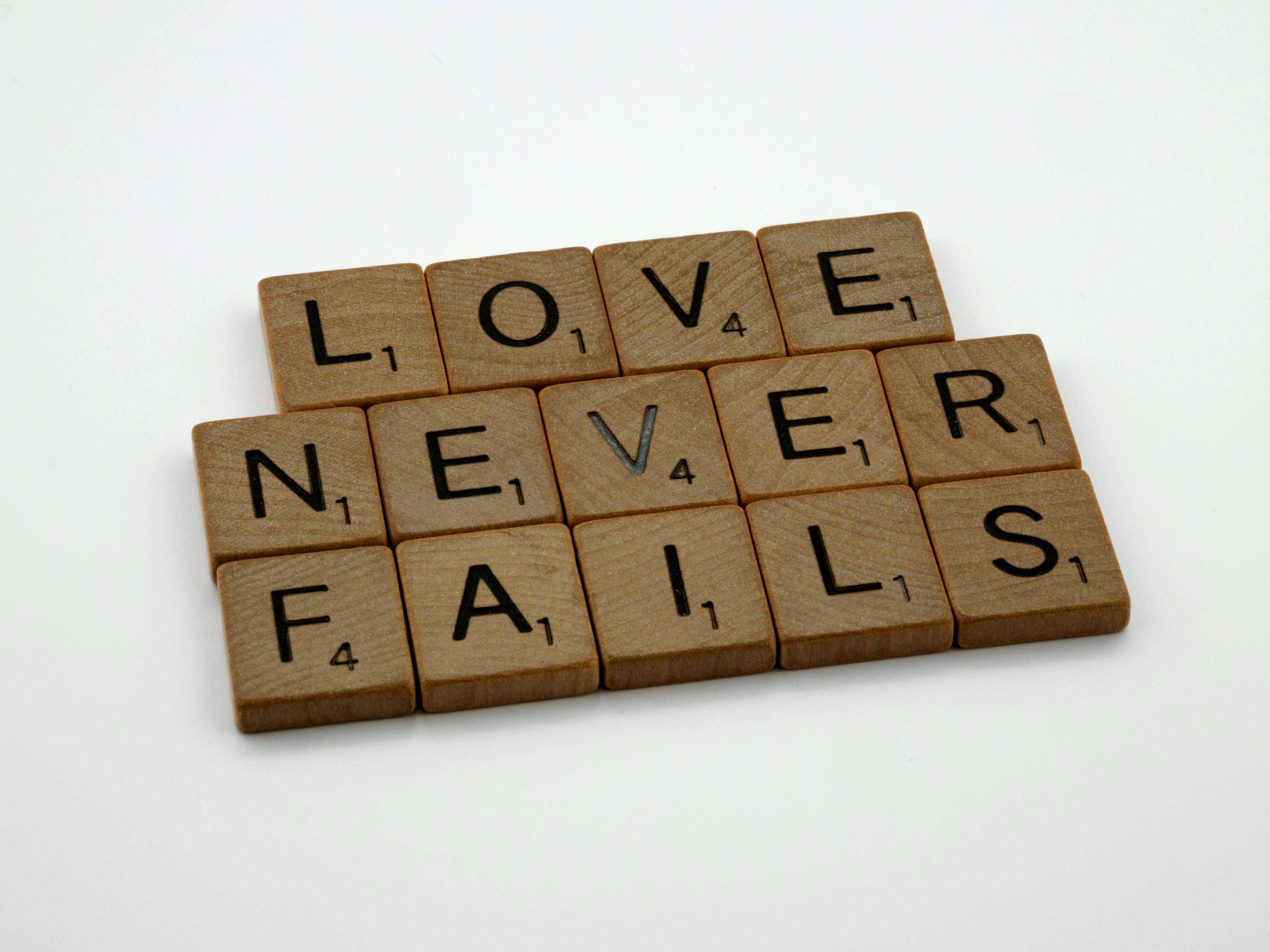 Fichas de Scrabble que deletrean "El amor nunca falla" | Fuente: Pexels