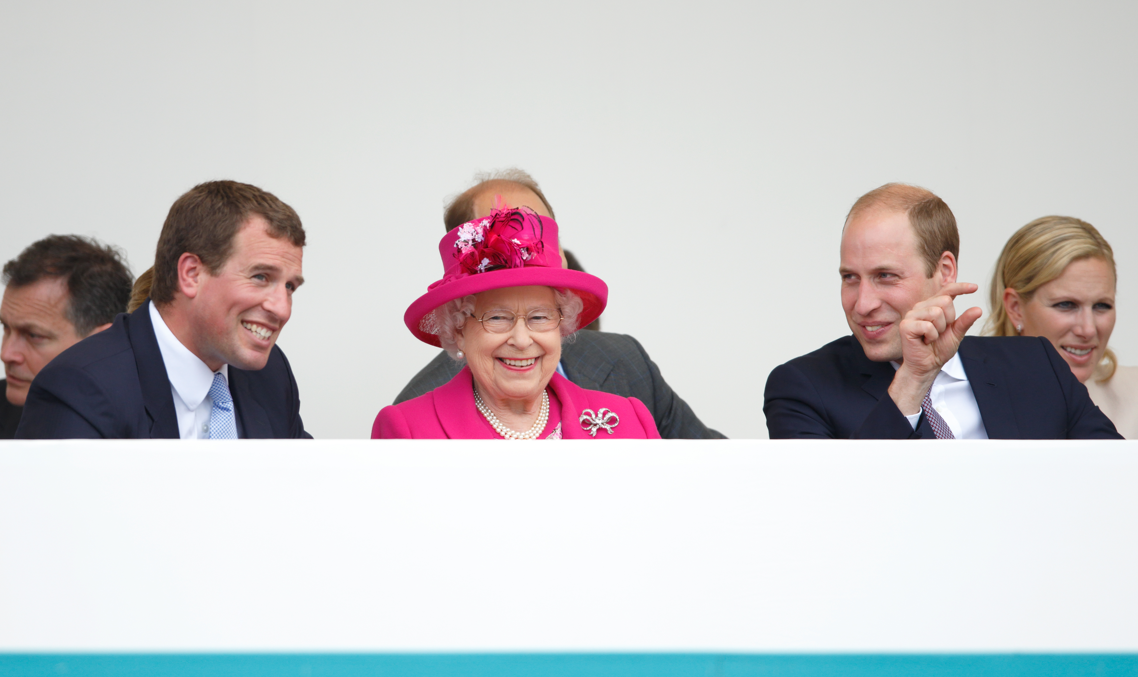 Peter Phillips, la reina Elizabeth II y el príncipe William observan un desfile de carnaval en las celebraciones del "Almuerzo del Patrón" con motivo del 90 cumpleaños de la reina Isabel II en The Mall el 12 de junio de 2016 en Londres, Inglaterra | Fuente: Getty Images