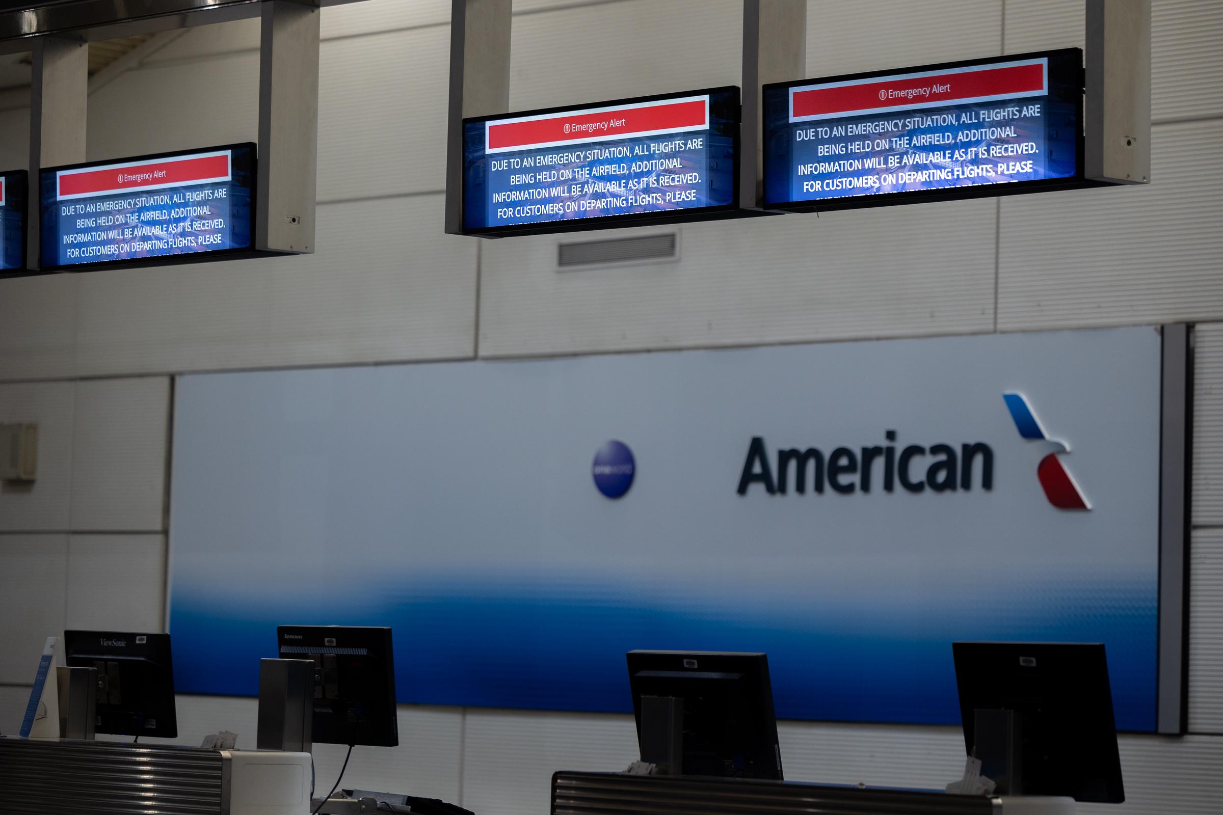 El mostrador de facturación de American Airlines en el Aeropuerto Nacional Ronald Reagan muestra un mensaje de emergencia tras la colisión entre un vuelo de American Airlines y un helicóptero del Ejército en Washington, D.C., el 30 de enero de 2025. | Fuente: Getty Images