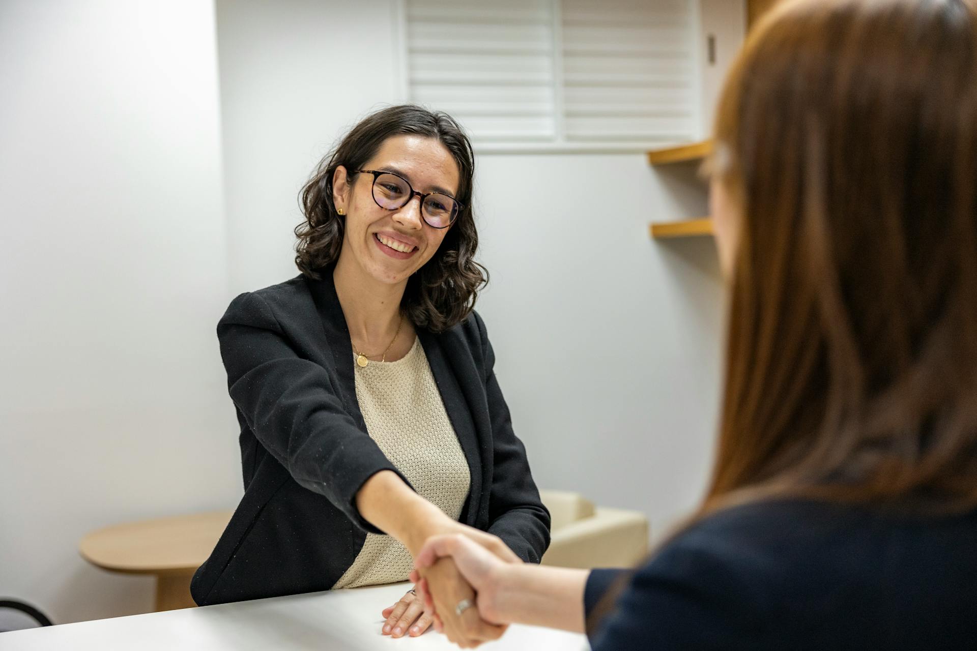 Mujer dando la mano en una oficina | Fuente: Pexels