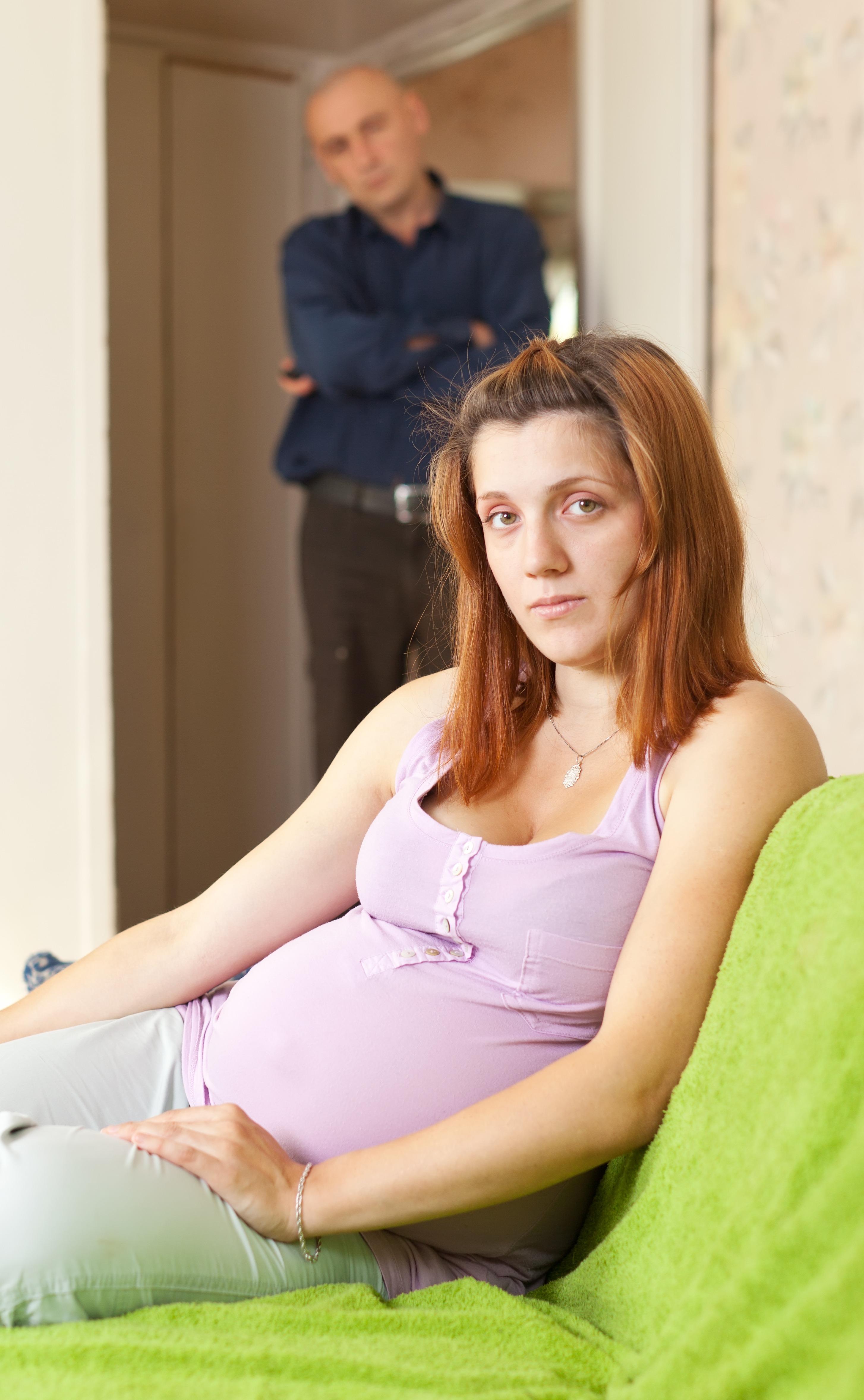 Mujer embarazada con un hombre de pie detrás de ella | Fuente: Shutterstock