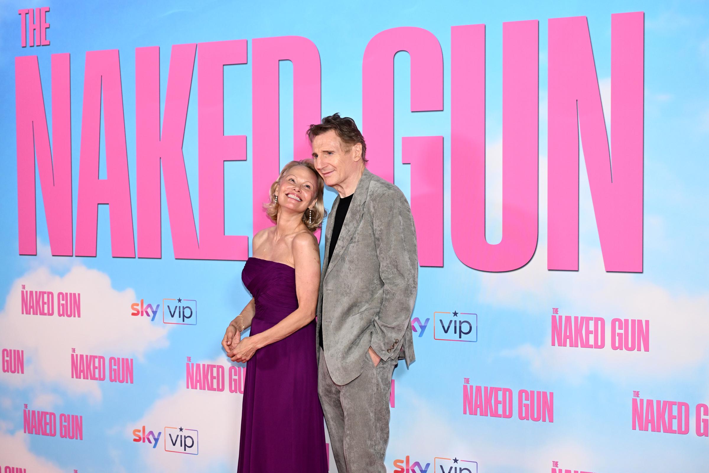 Pamela Anderson le sonríe a Liam Neeson mientras él también sonríe a la cámara durante el estreno en el Reino Unido de "The Naked Gun" en Cineworld Leicester Square, en Londres, Inglaterra, el 22 de julio de 2025 | Fuente: Getty Images