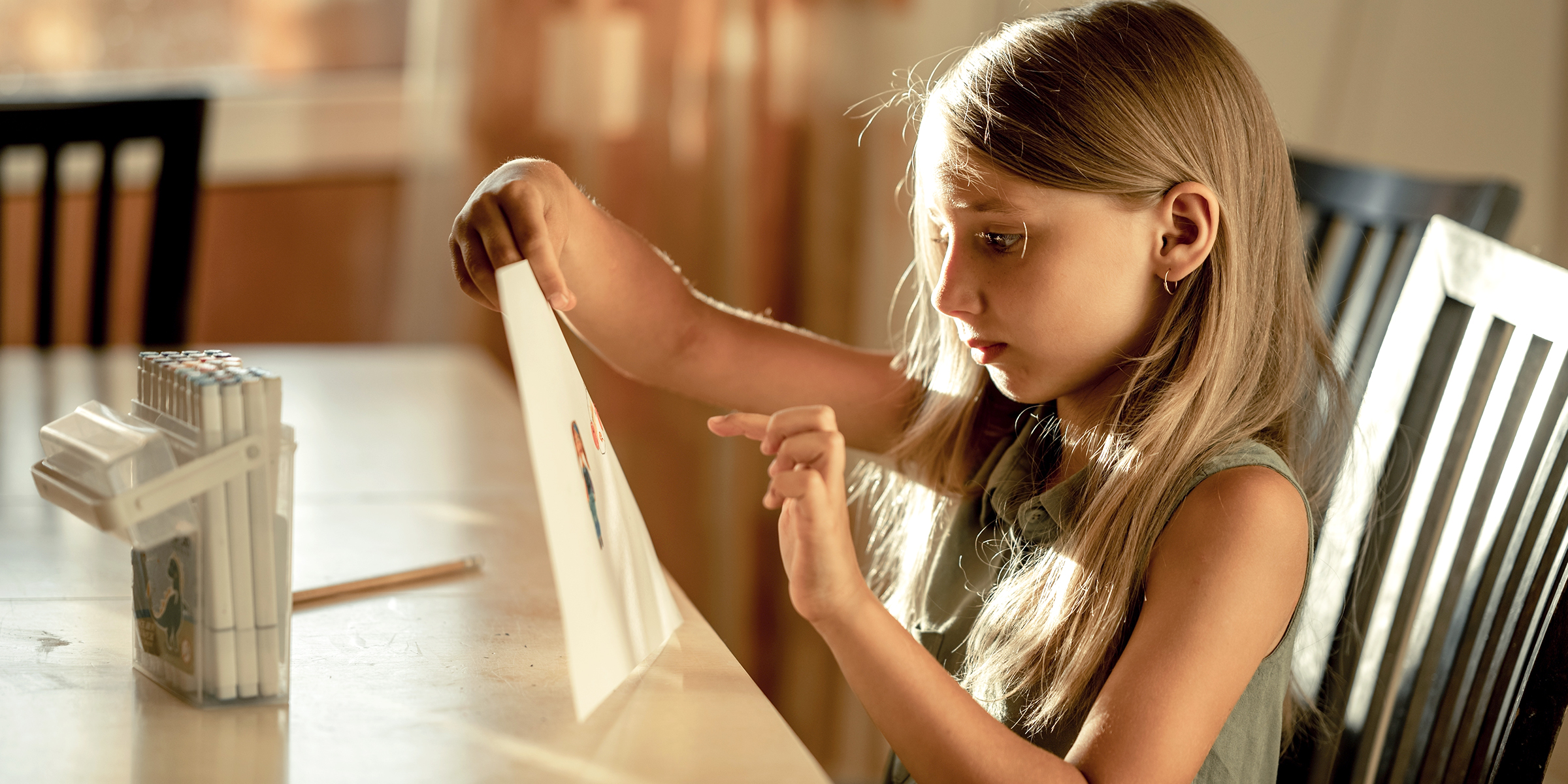 Una niña sujetando un dibujo | Fuente: Shutterstock