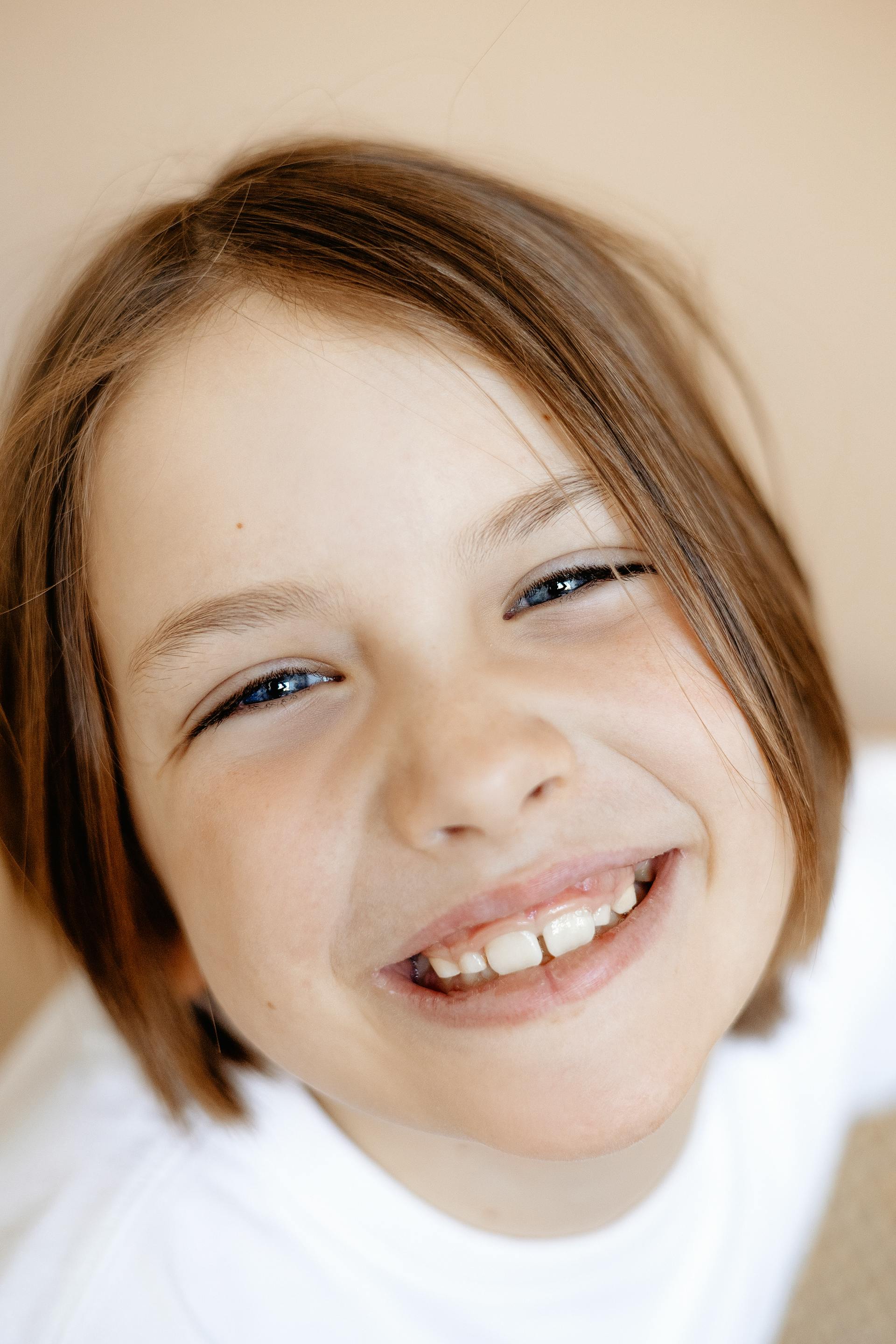 Una chica sonriente mirando hacia arriba | Fuente: Pexels