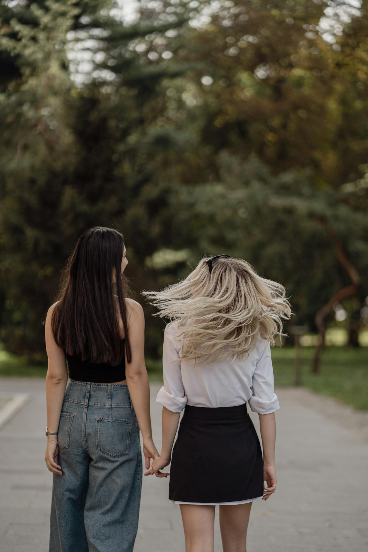 Dos mujeres tomadas de la mano mientras pasean | Fuente: Pexels