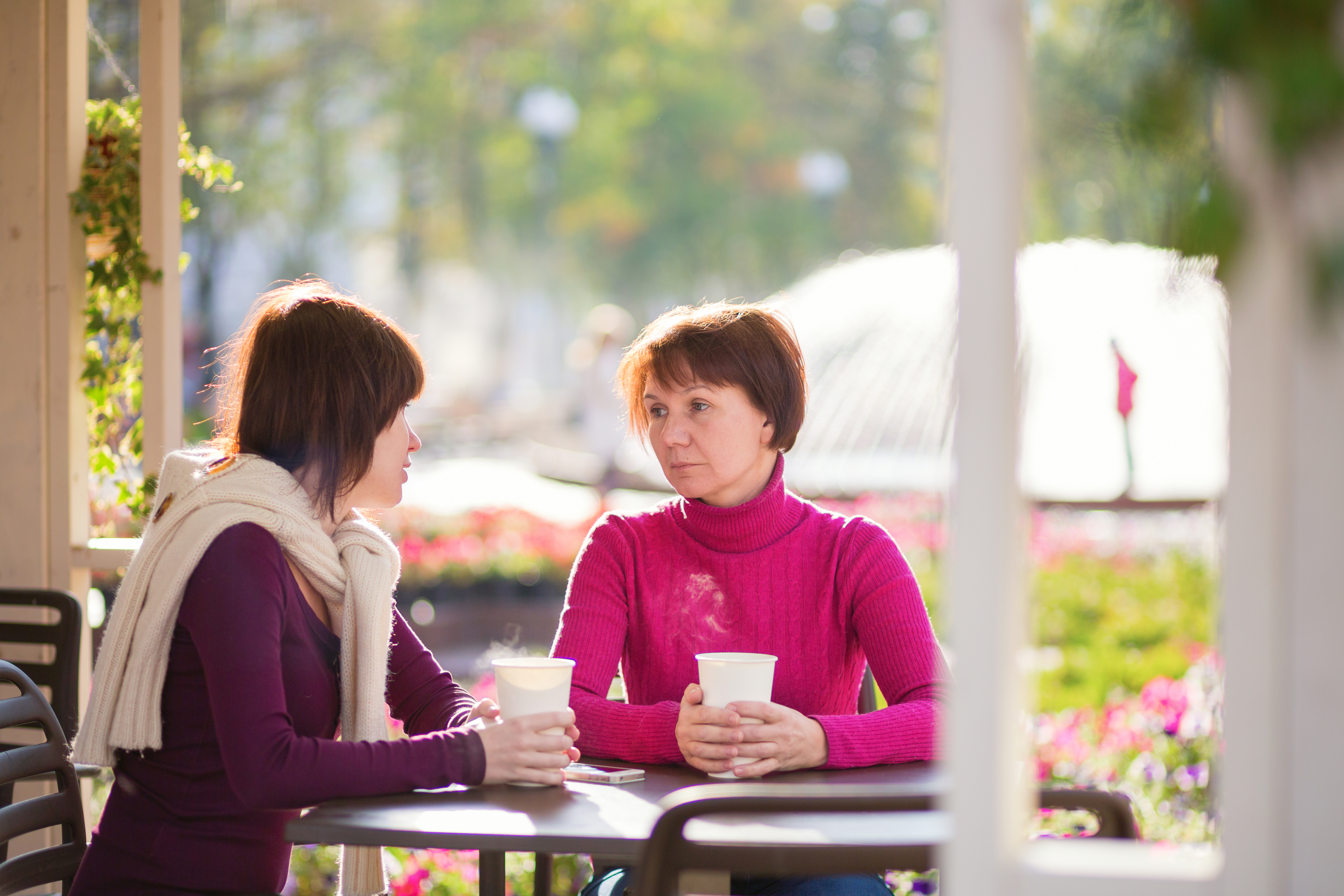 Una mujer joven y una mujer mayor están sentadas en una cafetería | Fuente: Shutterstock