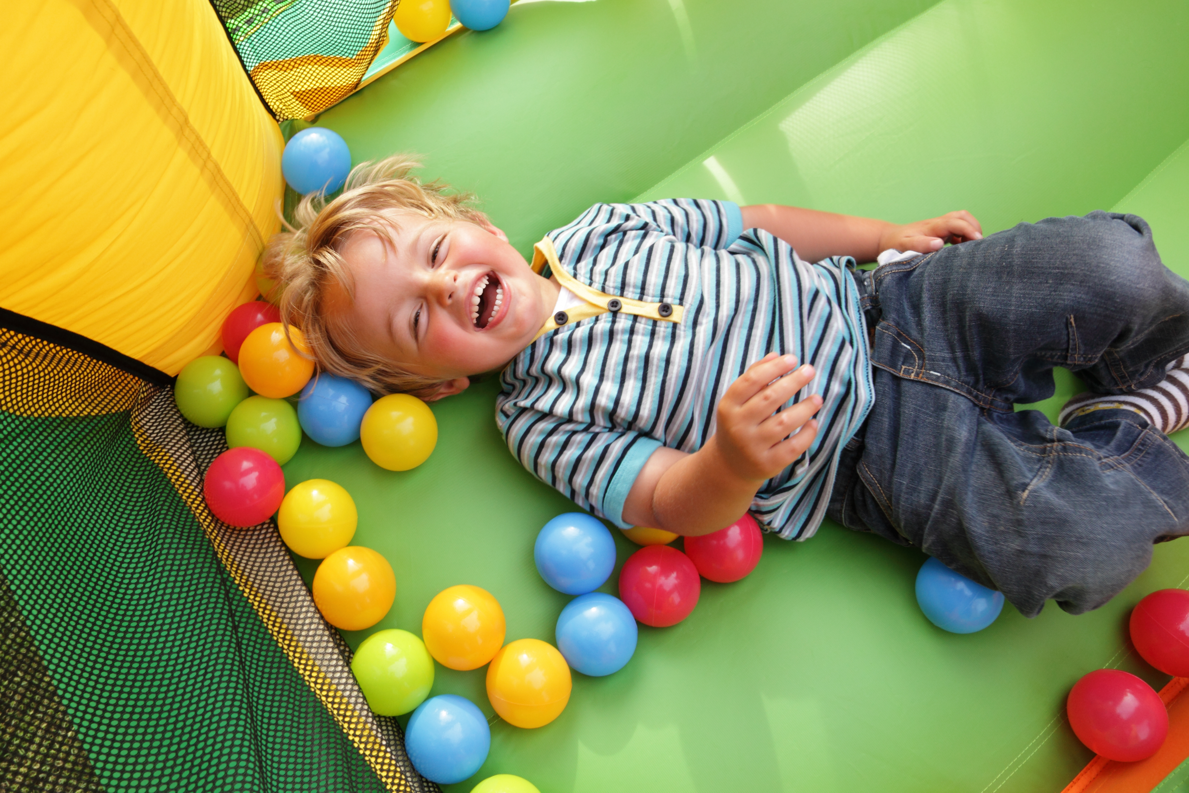 Niño de 3 años tumbado y riendo | Fuente: Shutterstock.com