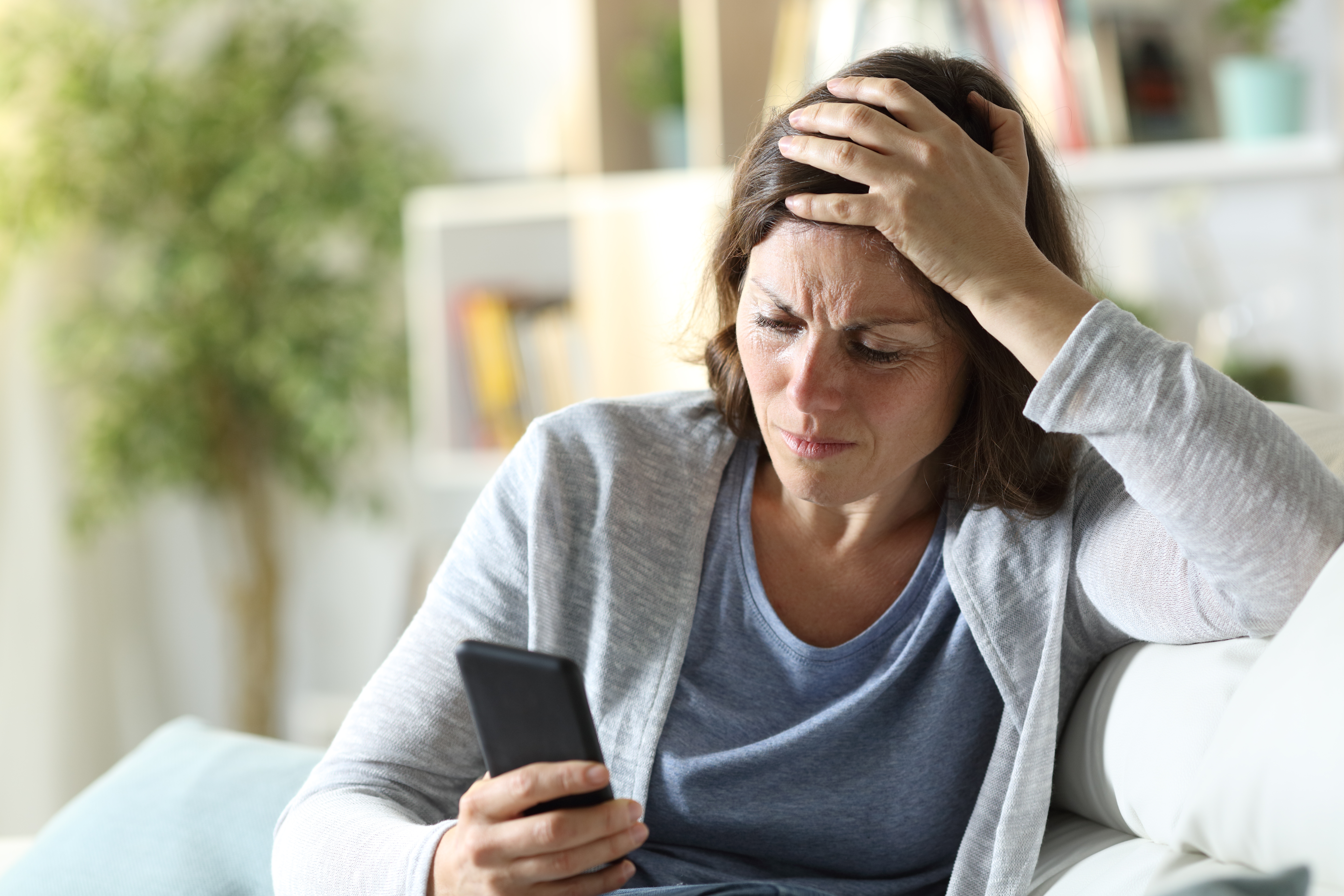 Mujer preocupada mira su teléfono | Foto: Shutterstock