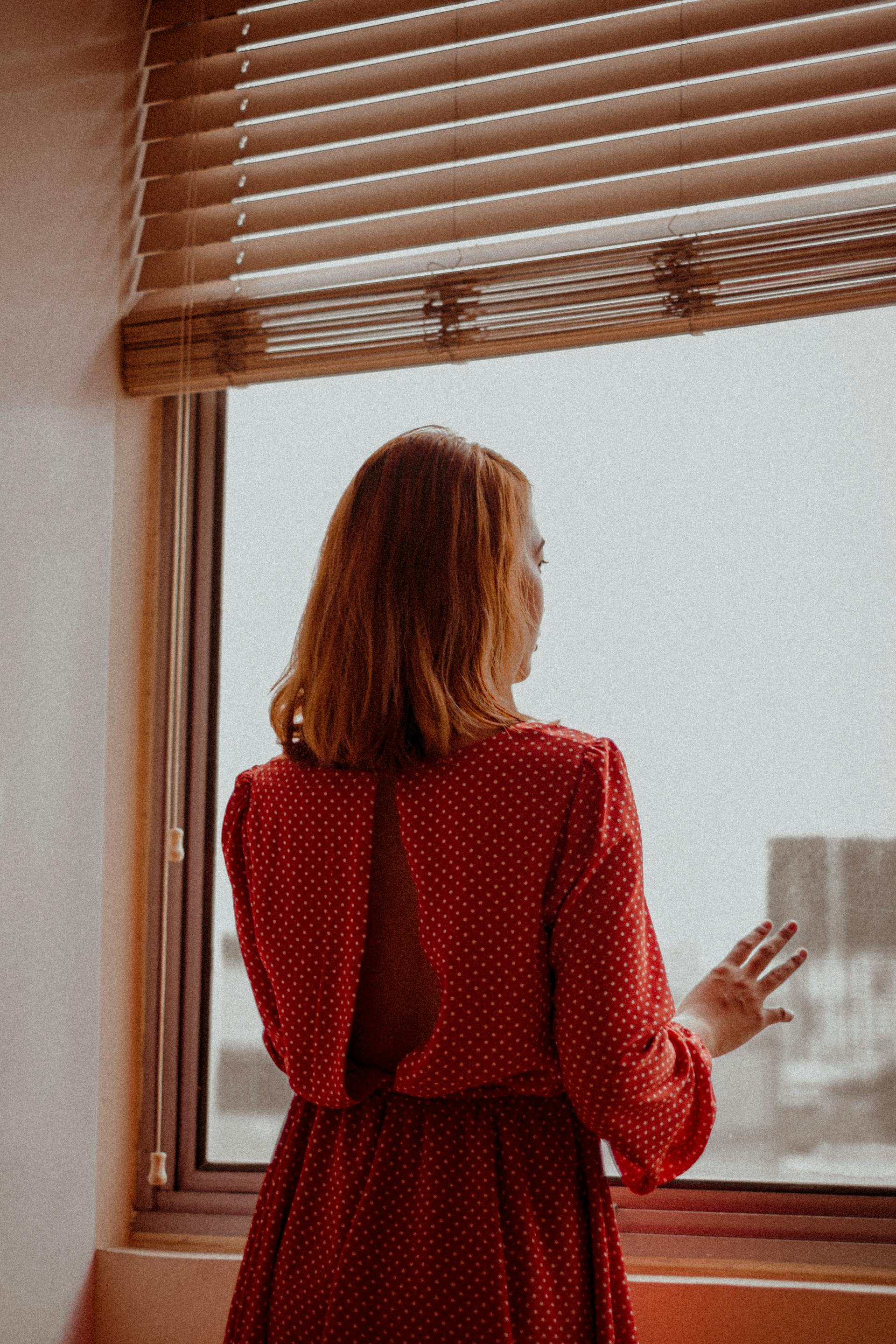 Una mujer mirando por la ventana | Fuente: Pexels