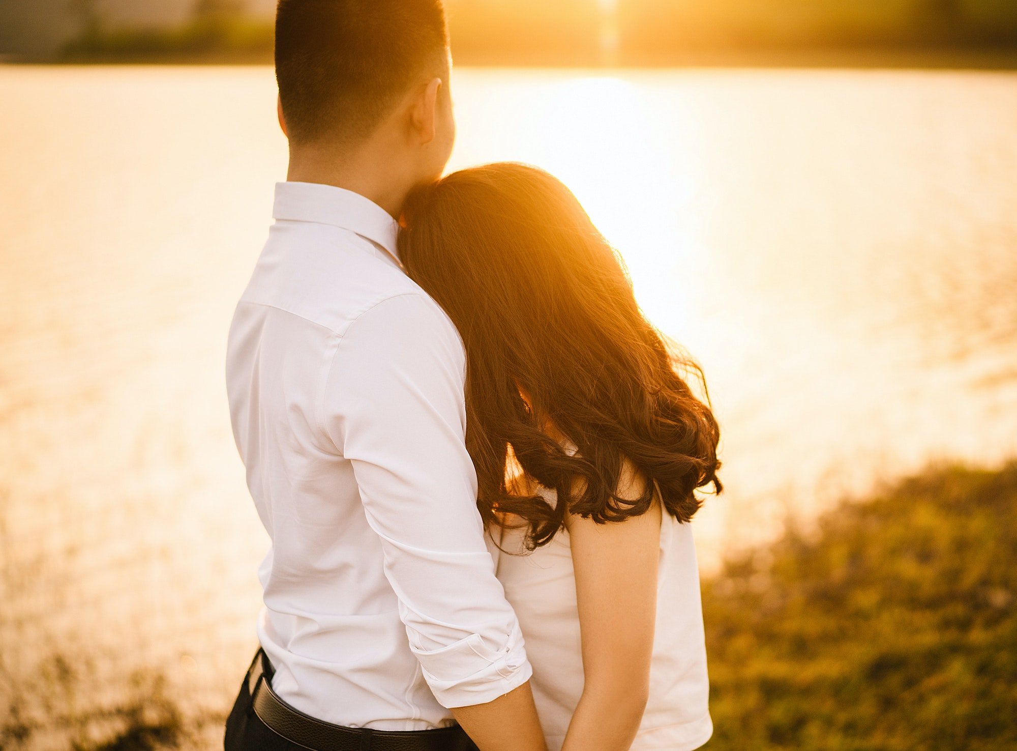 Pareja de enamorados miran el ocaso del Sol. | Foto: Shutterstock