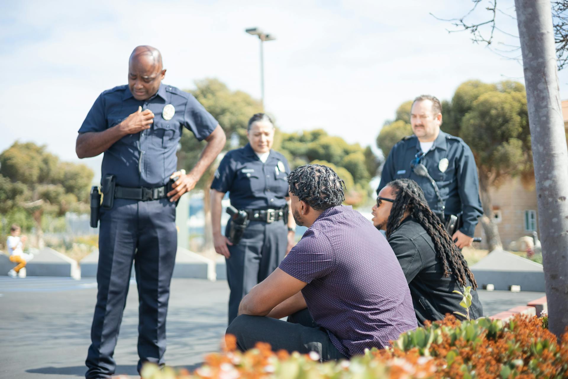 Agentes de policía hablando con dos hombres | Fuente: Pexels