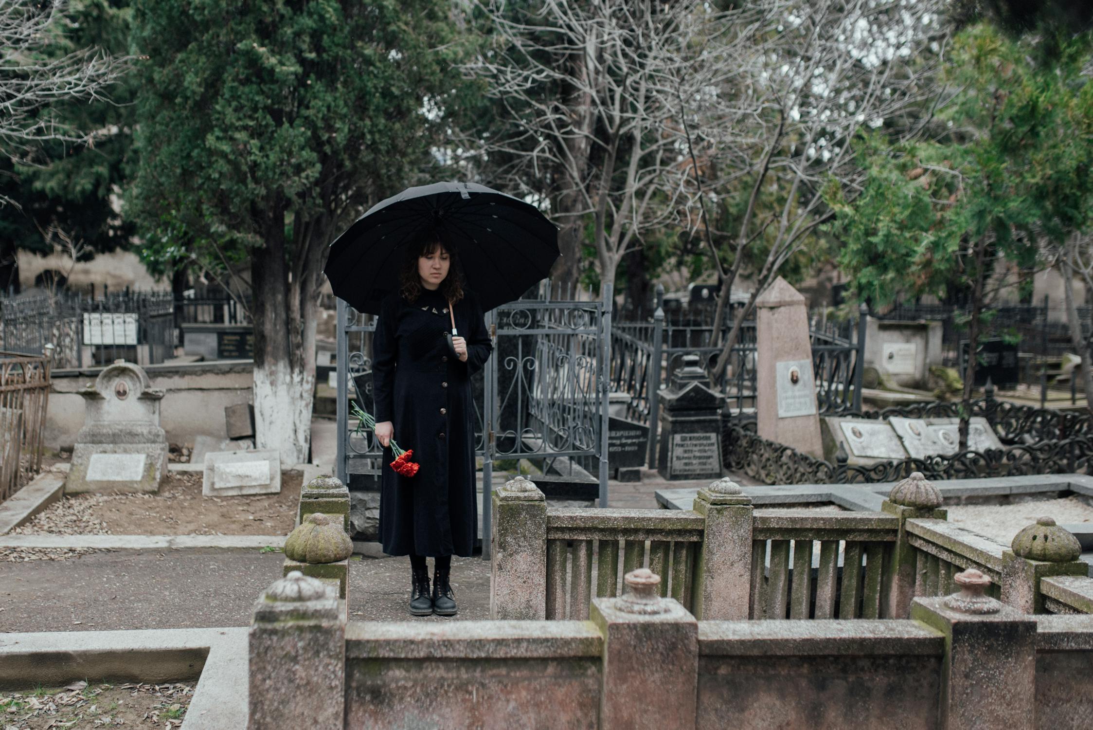 Una joven de pie en el cementerio ⏐ Fuente: Pexels