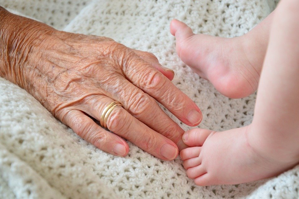 Mano de abuela sobre el pie de un bebé| Foto: Pixabay