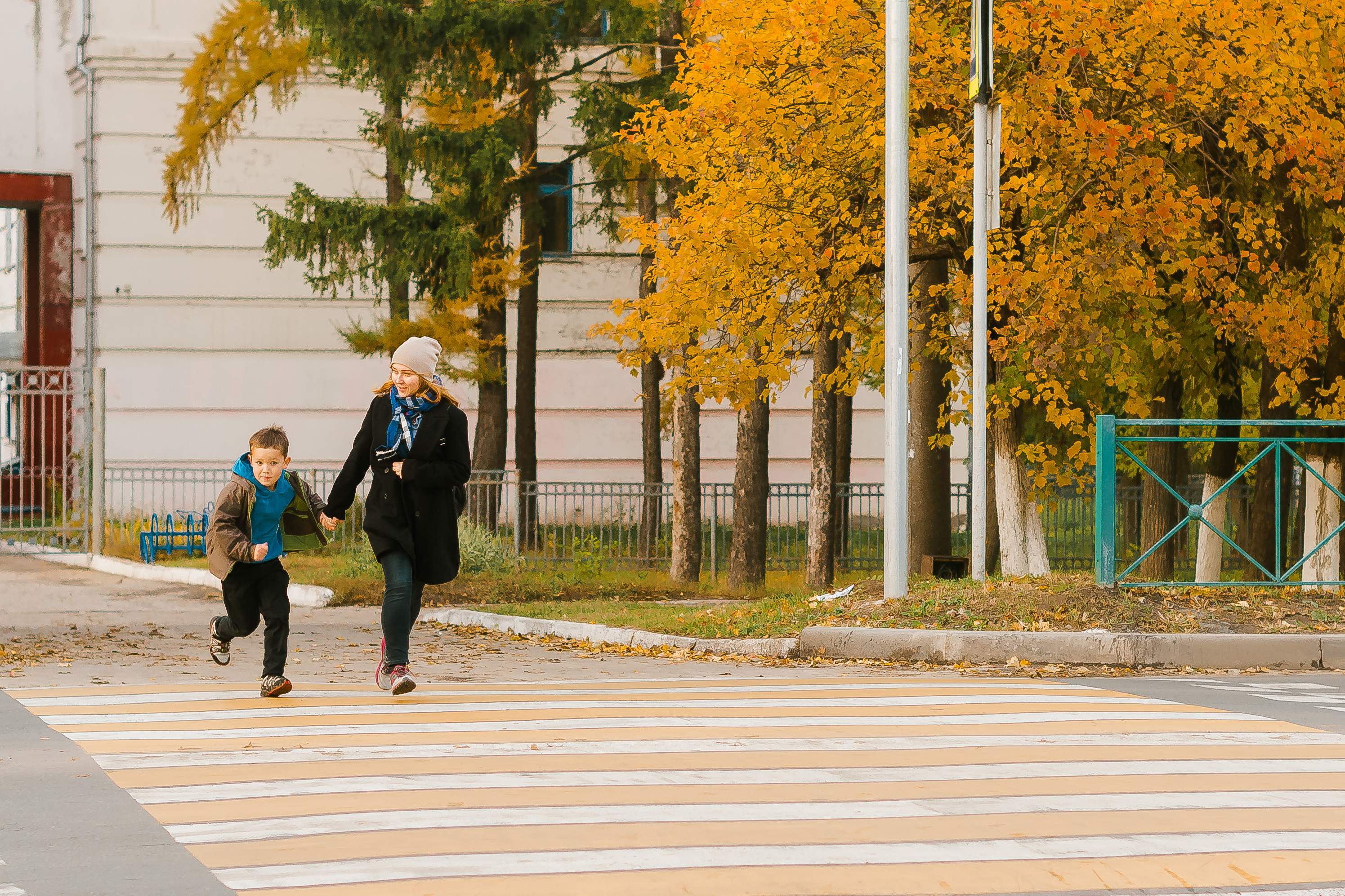 Una madre con su hijo cruza la carretera en la ciudad. | Fuente: Shutterstock