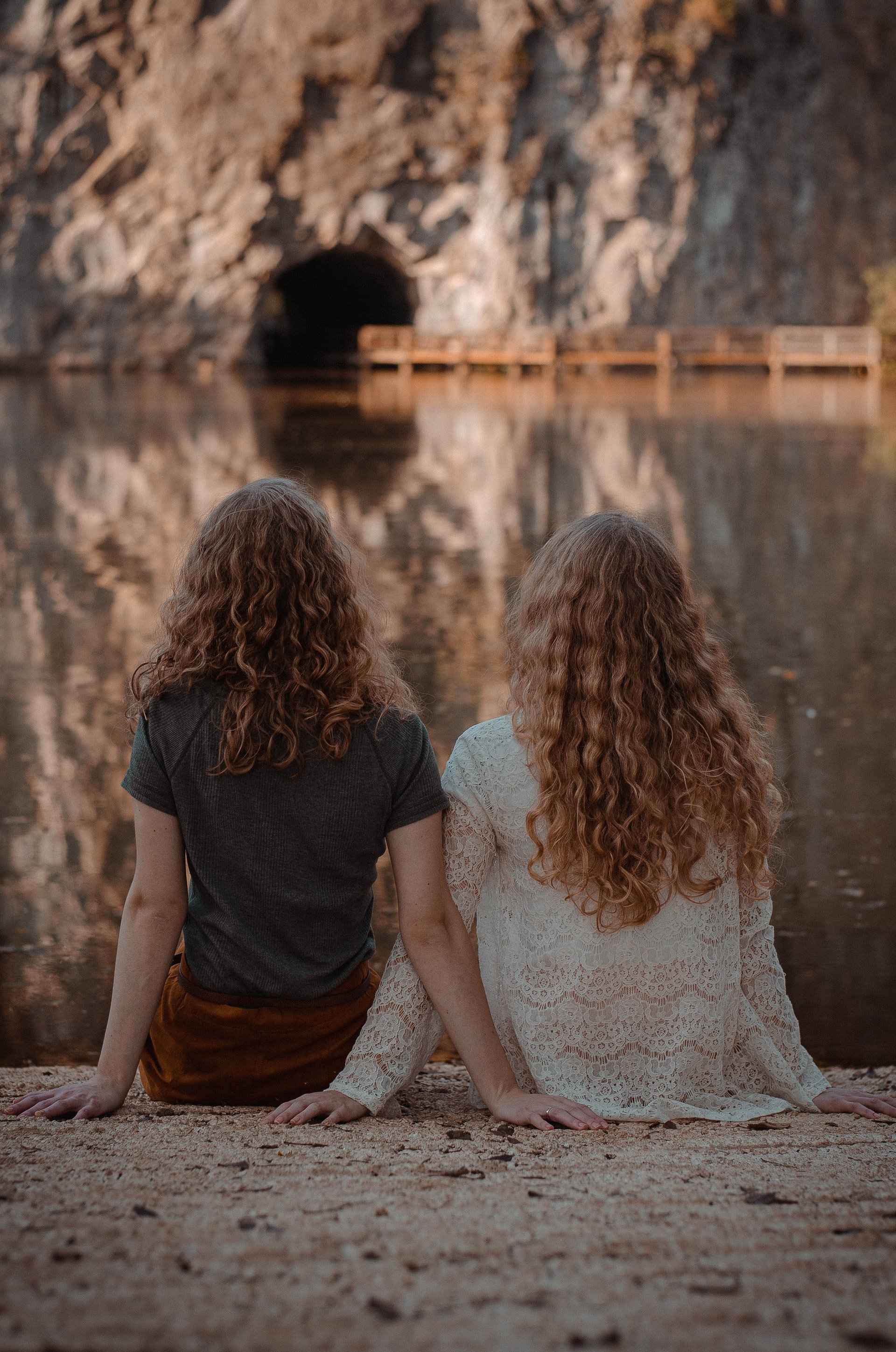 Dos chicas sentadas frente a un lago. | Foto: Pexels