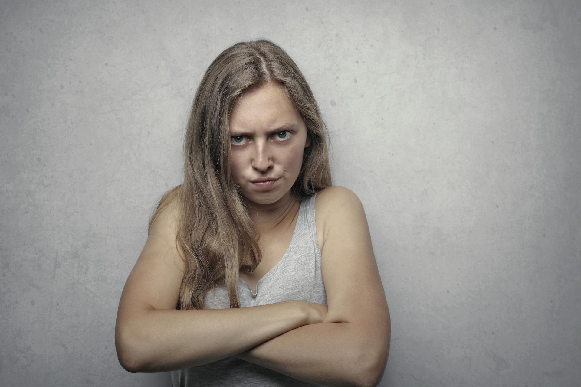 Una mujer enfadada de pie con los brazos cruzados | Fuente: Pexels